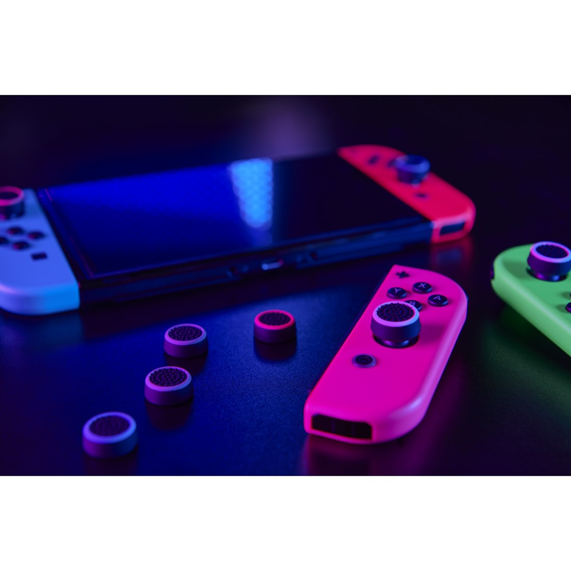 Nintendo Switch-Controller und Controller-Daumengriffe auf dunkler Oberfläche, mit schwarzem Hintergrund.