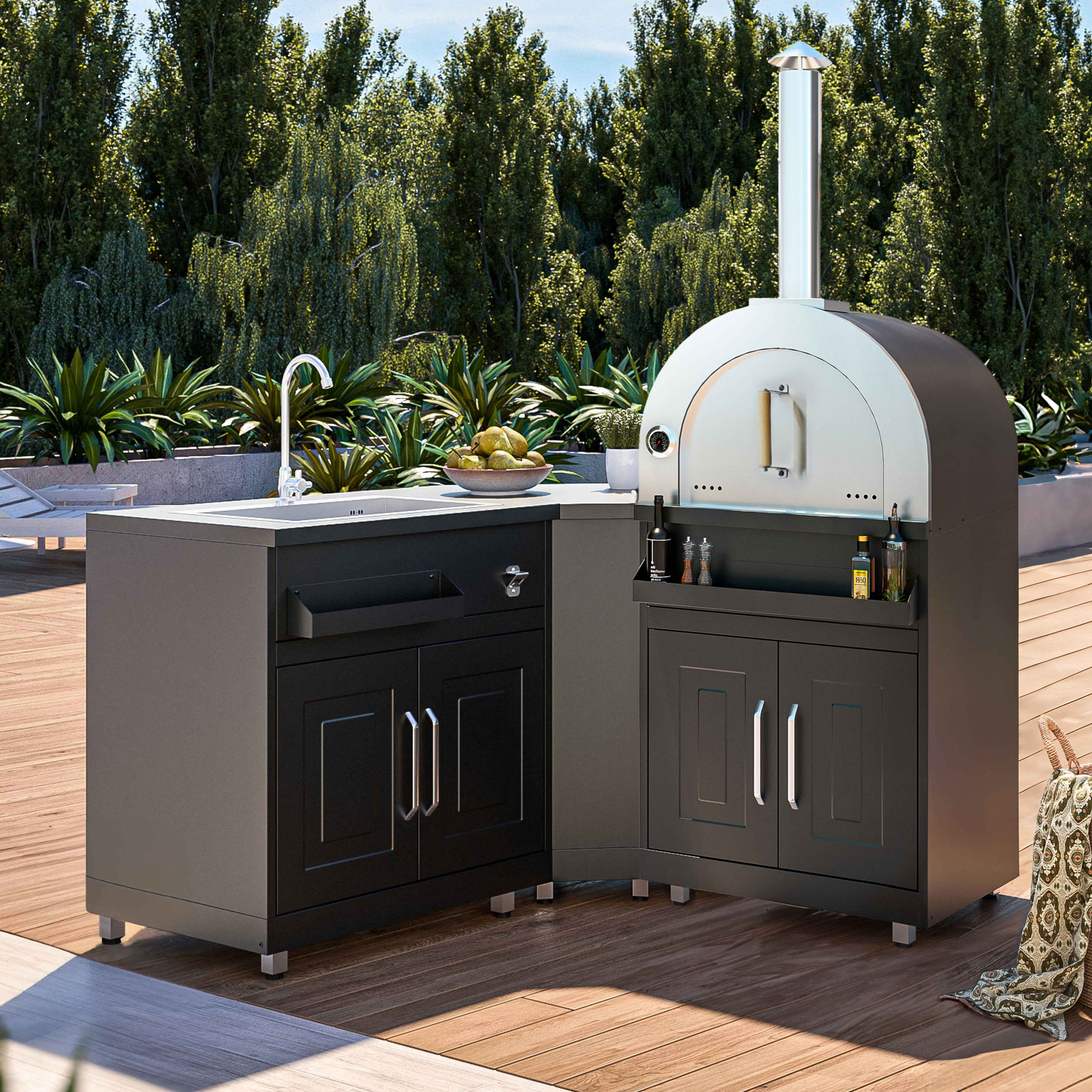 Outdoorküche mit Pizzaofen, Spüle und Theke auf Holzterrasse.