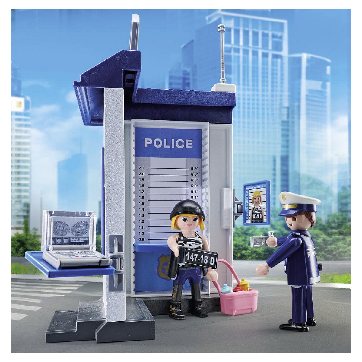 Posterunek policji Playmobil z figurkami policjanta, podejrzanego i tłem miasta.