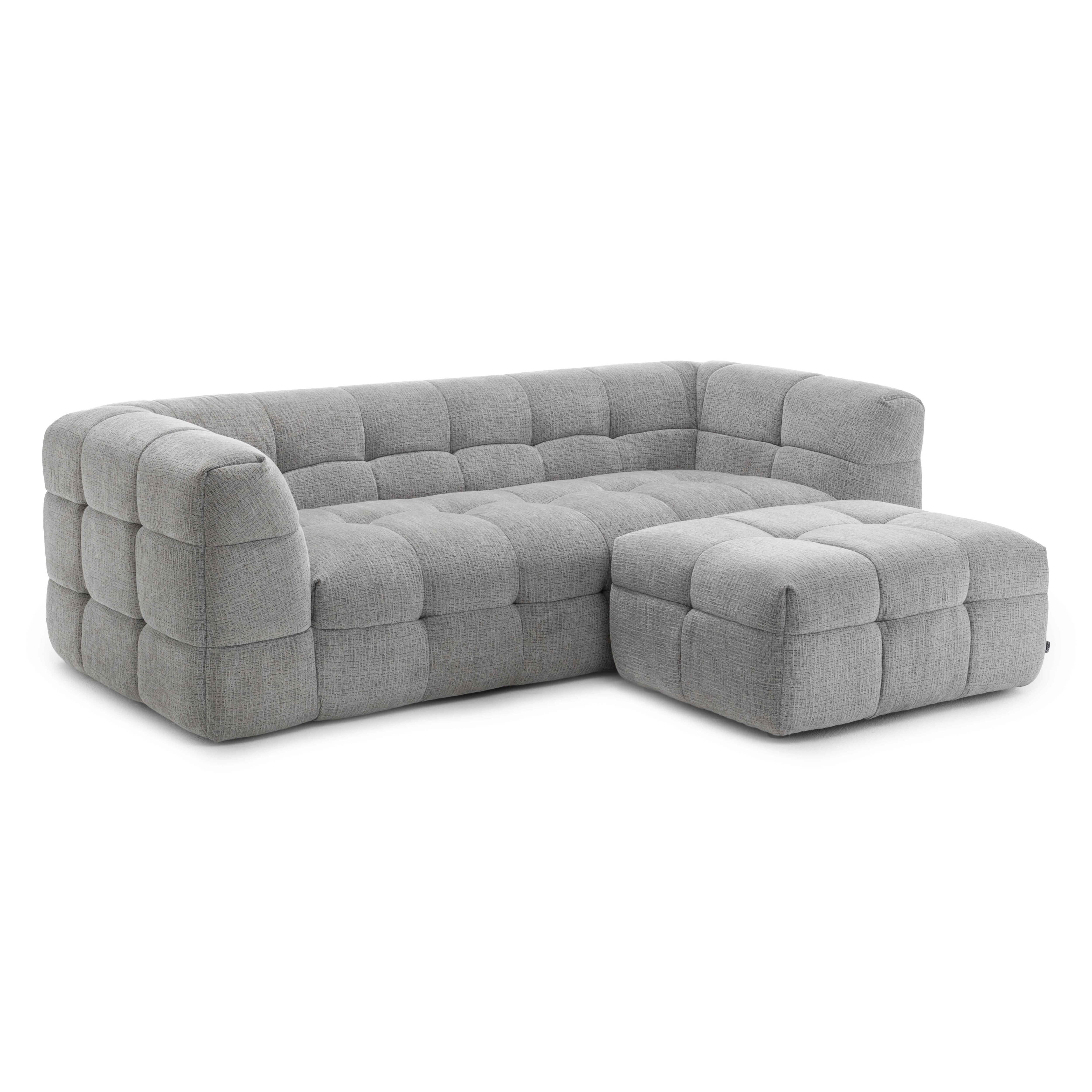 Graues, getuftetes Sofa mit Ottomane, vor weißem Hintergrund.