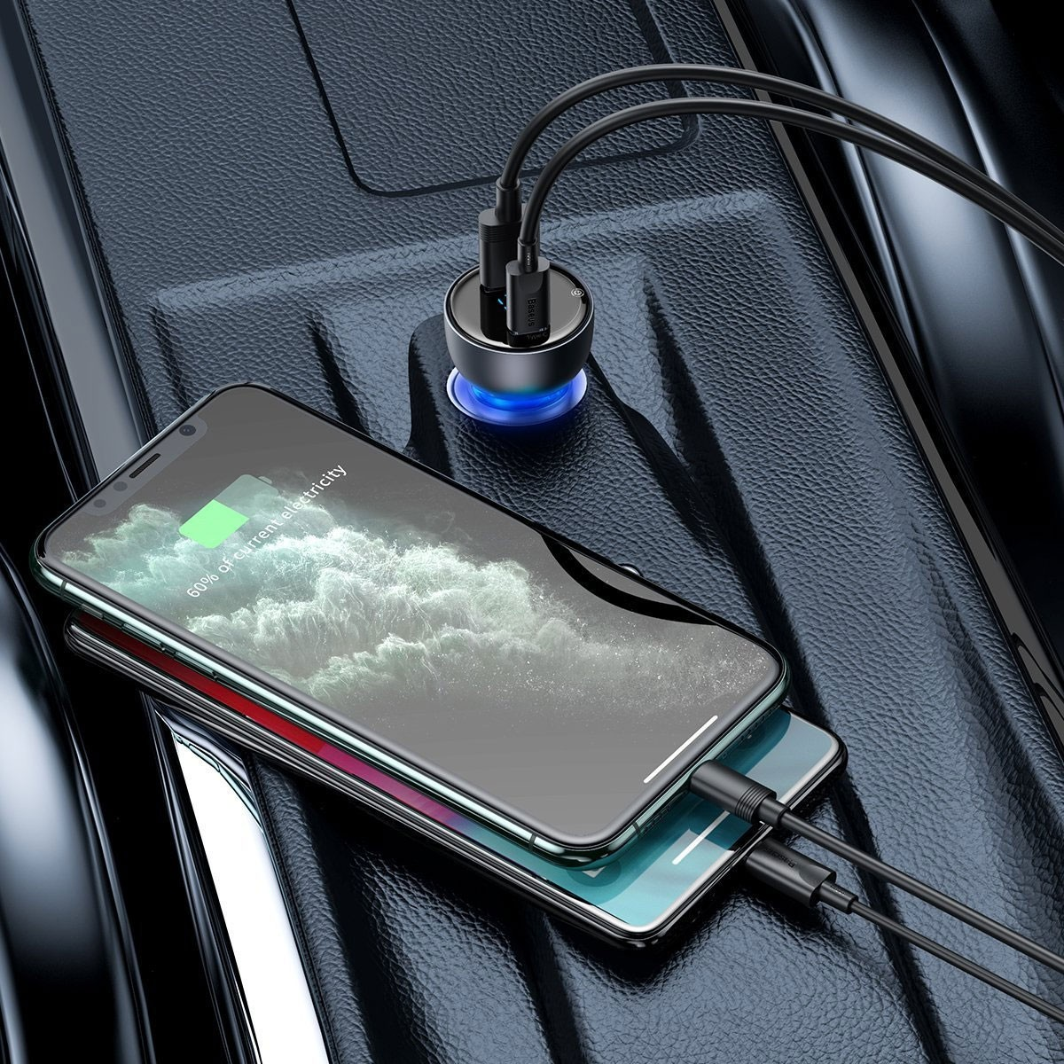 Due telefoni si stanno caricando in un caricabatterie per auto. I fili sono collegati. Il caricabatterie è in una console per auto.