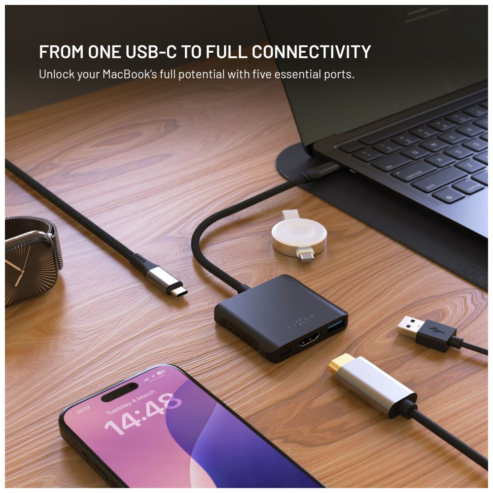 Ein Hub mit Kabeln und ein Telefon, eine Uhr und ein Laptop. Es befindet sich auf einer weißen Oberfläche.