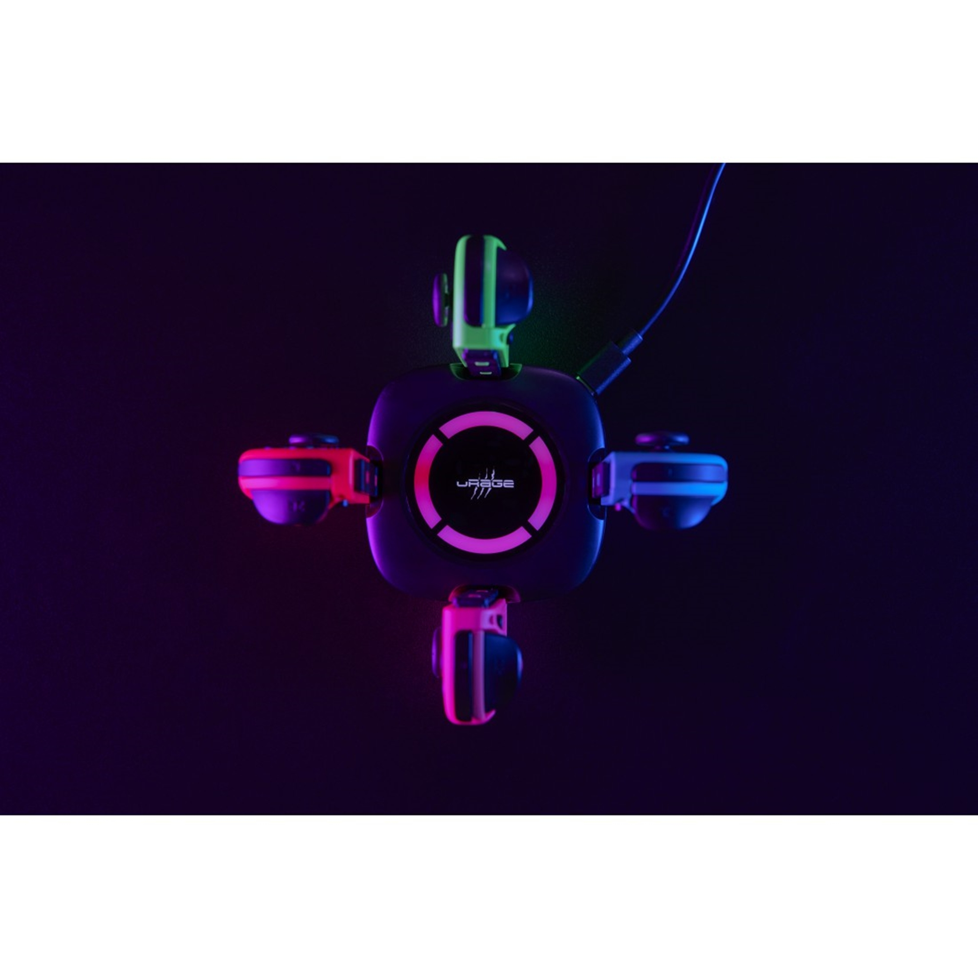 Eine Ladestation mit Gamecontrollern. Controller sind grün, rosa und blau. Dunkler Hintergrund.