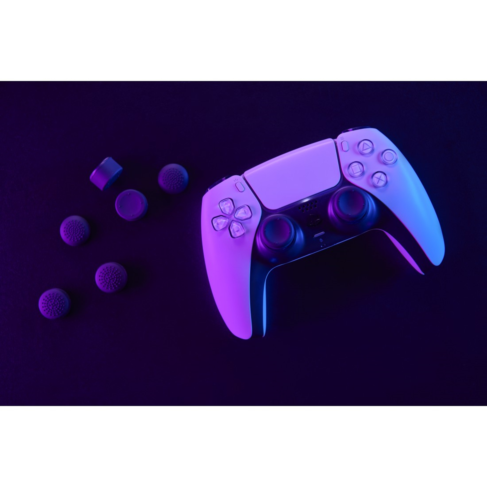 Ein weiß-violetter Gamecontroller mit Daumensticks und zusätzlichen, die auf einer dunkelvioletten Oberfläche verstreut sind.