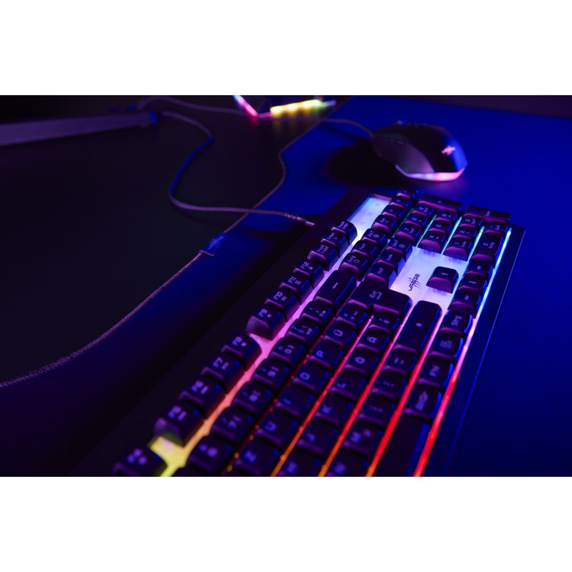 Gaming-Tastatur mit farbigen Tasten und Maus, beide beleuchtet, auf dunkler Oberfläche mit blauem Licht.