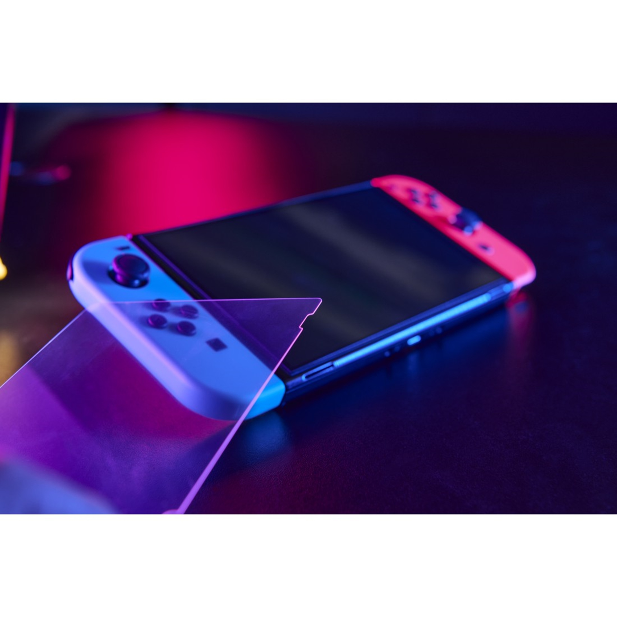 Eine Switch-Konsole mit blauen links und roten rechts Controllern, Displayschutz auf dunkler Oberfläche.