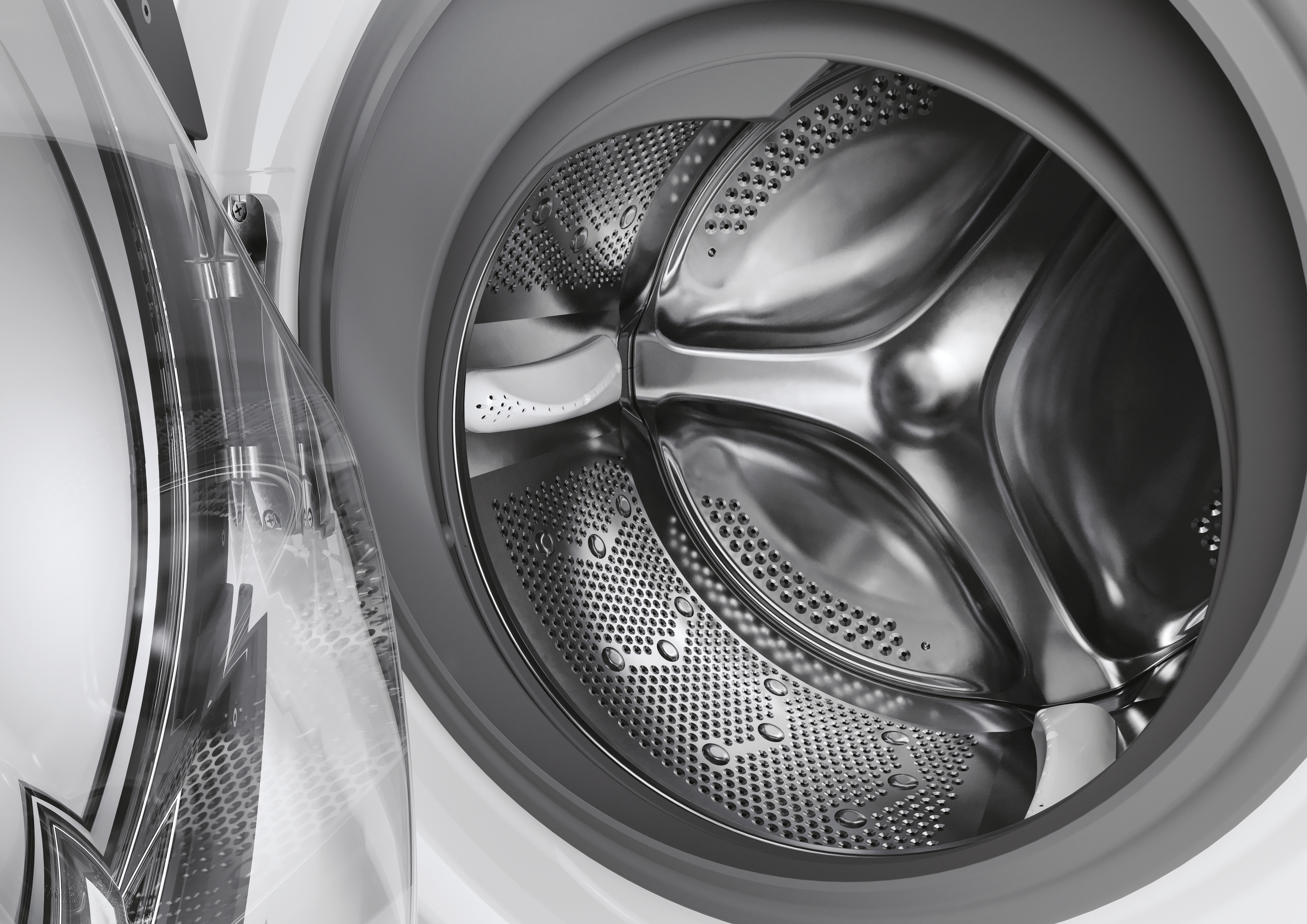L'interno del cestello di una lavatrice, con porta trasparente e goccioline d'acqua.