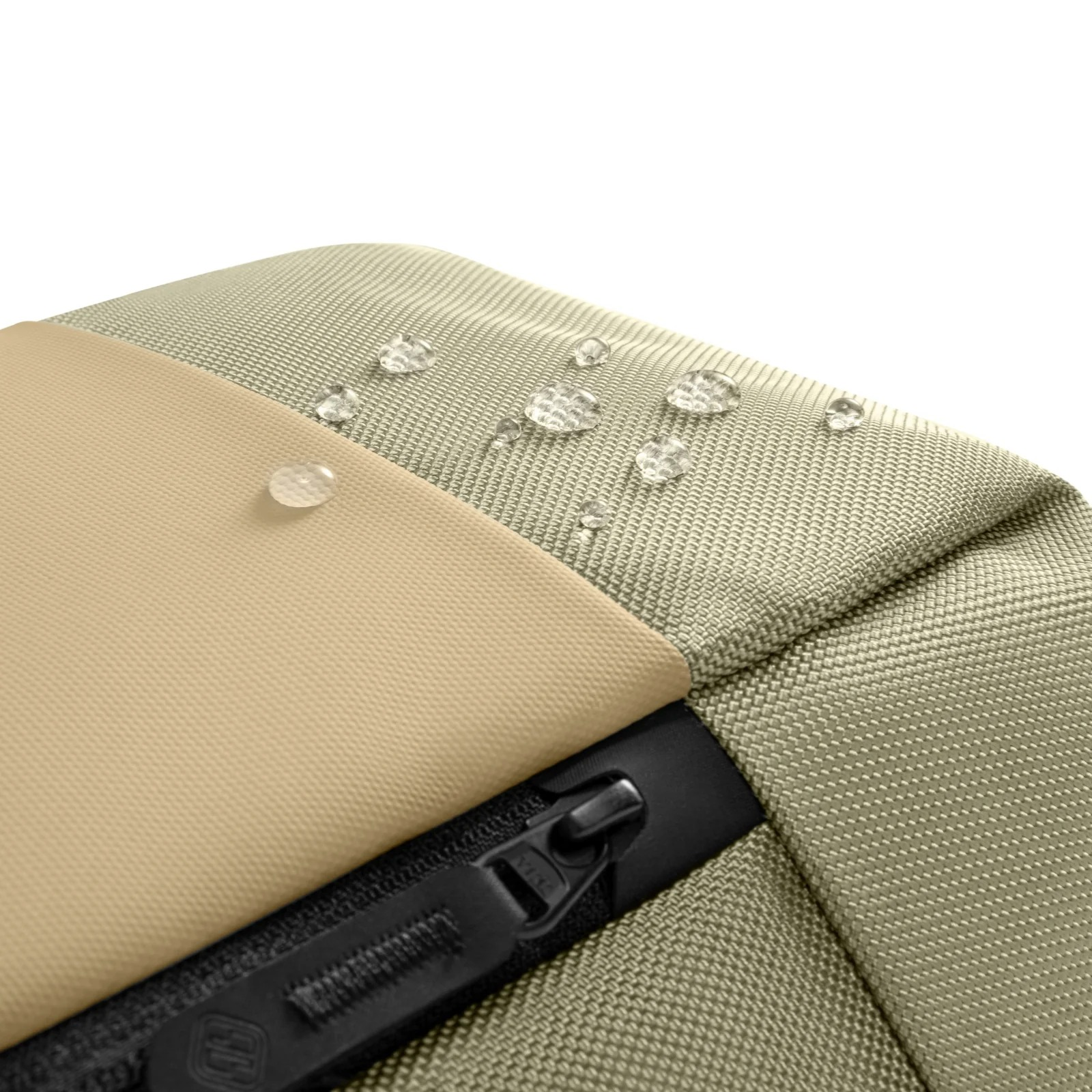 Zbliżenie na brązowy plecak z kroplami wody na powierzchni. Widoczny czarny zamek błyskawiczny.