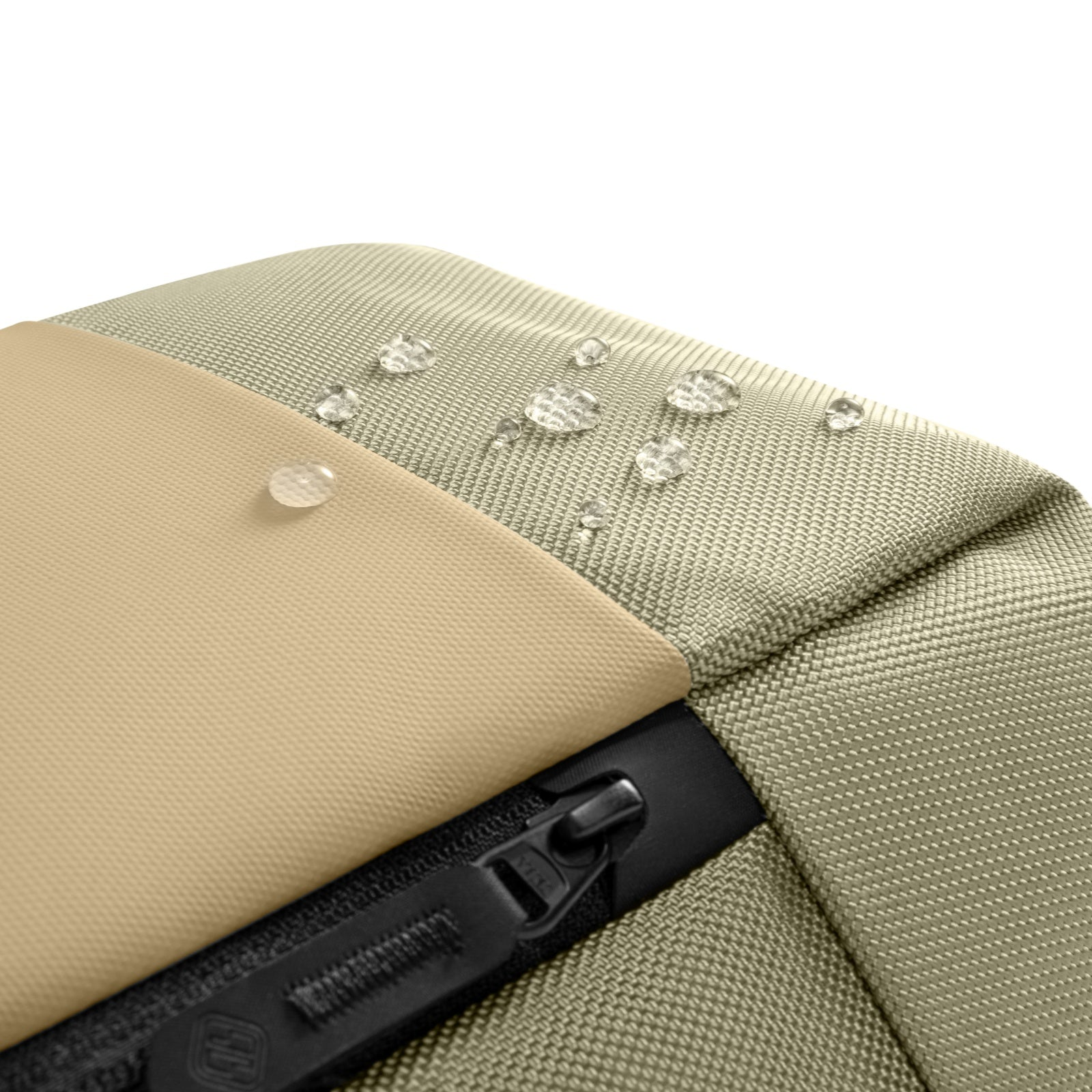 Zbliżenie na beżową i zieloną tkaninę torby z kroplami wody. Tkanina jest teksturowana.