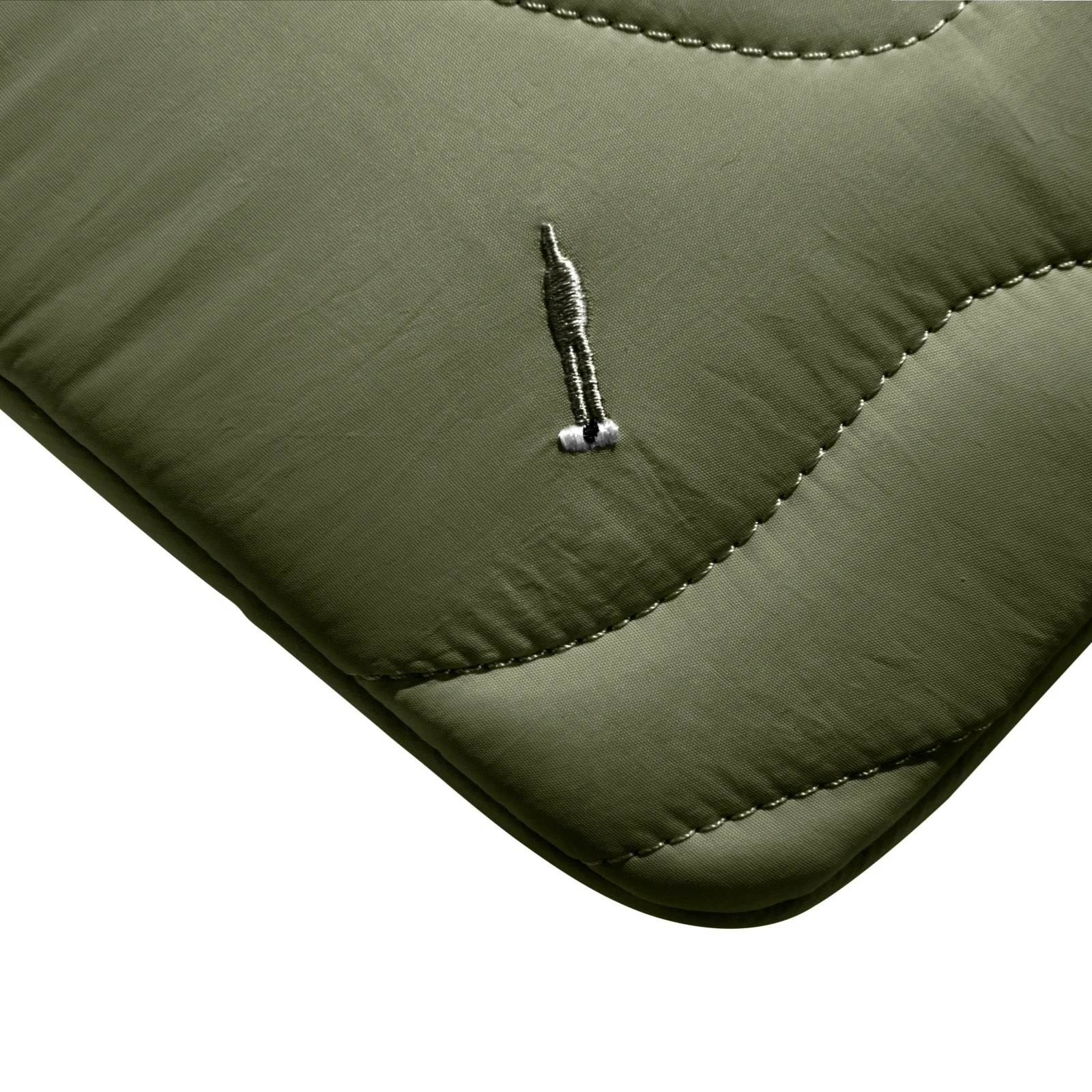 Zbliżenie na zieloną pikowaną tkaninę z małym wszytym logo. Tkanina jest wodoodporna.