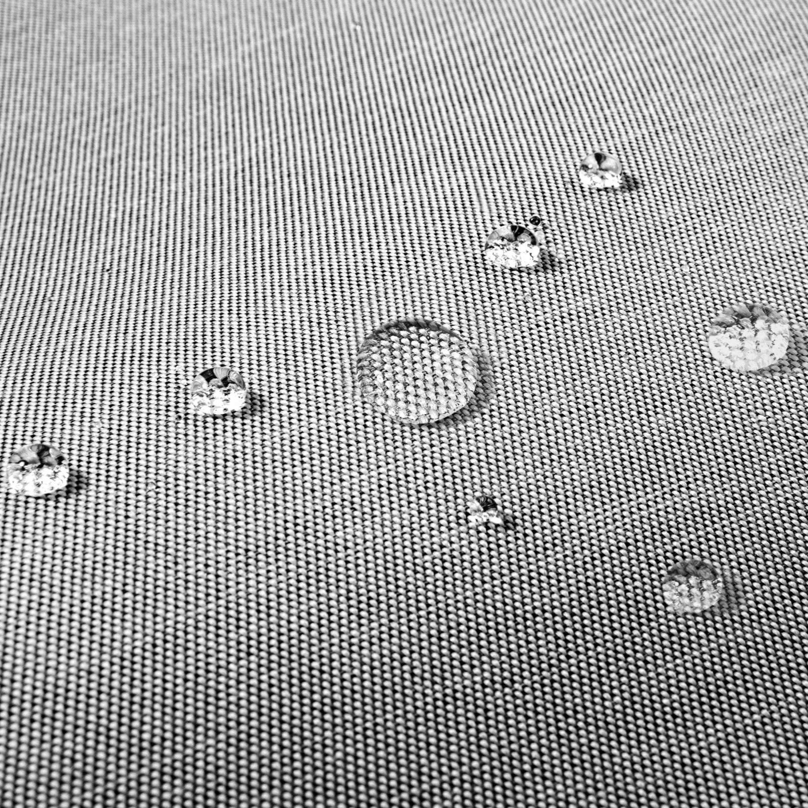 Zbliżenie kropelek wody na szarej, teksturowanej powierzchni. Krople różnią się wielkością i odbijają światło.