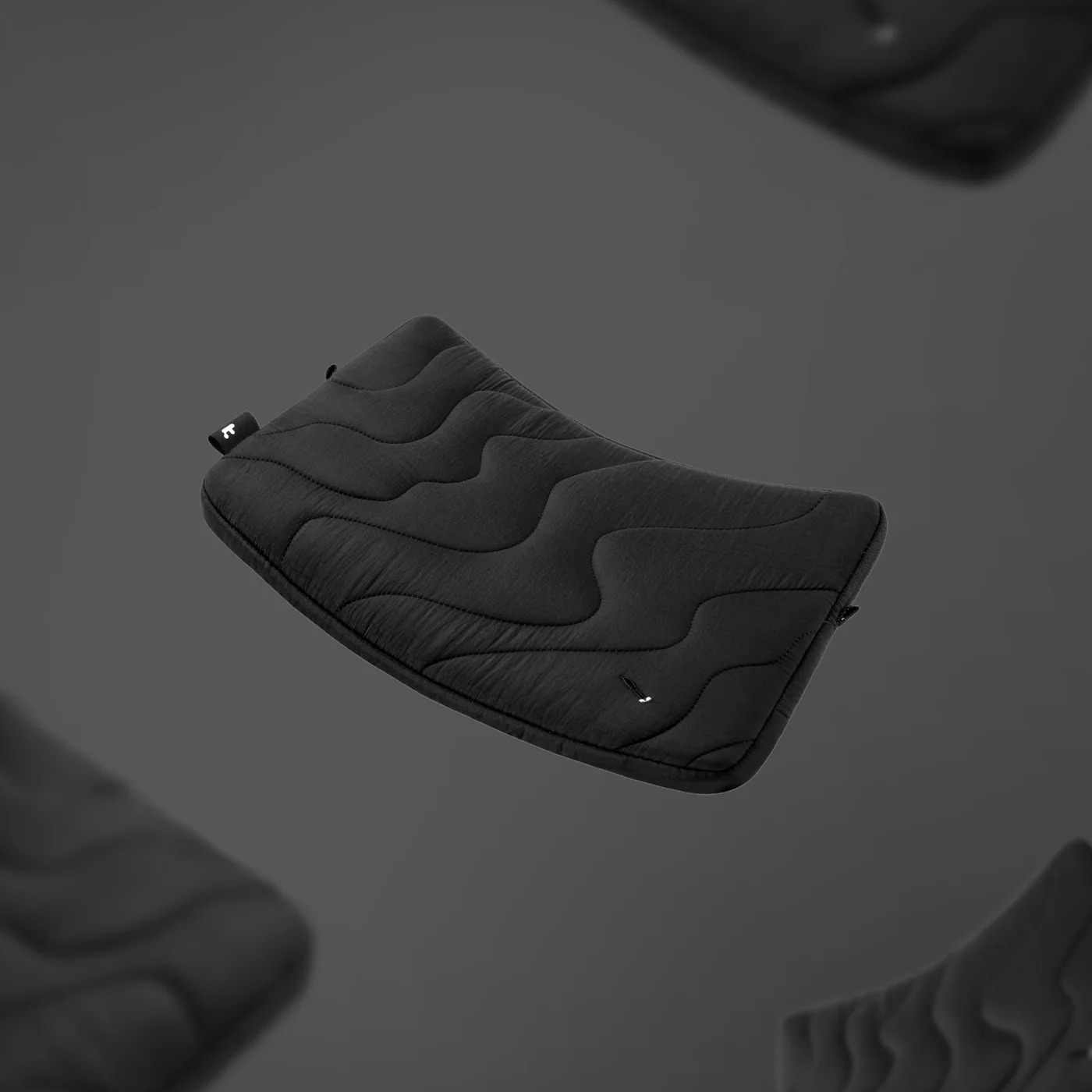 Pływające czarne etui na laptopa na ciemnoszarym tle. Niektóre są rozmyte.