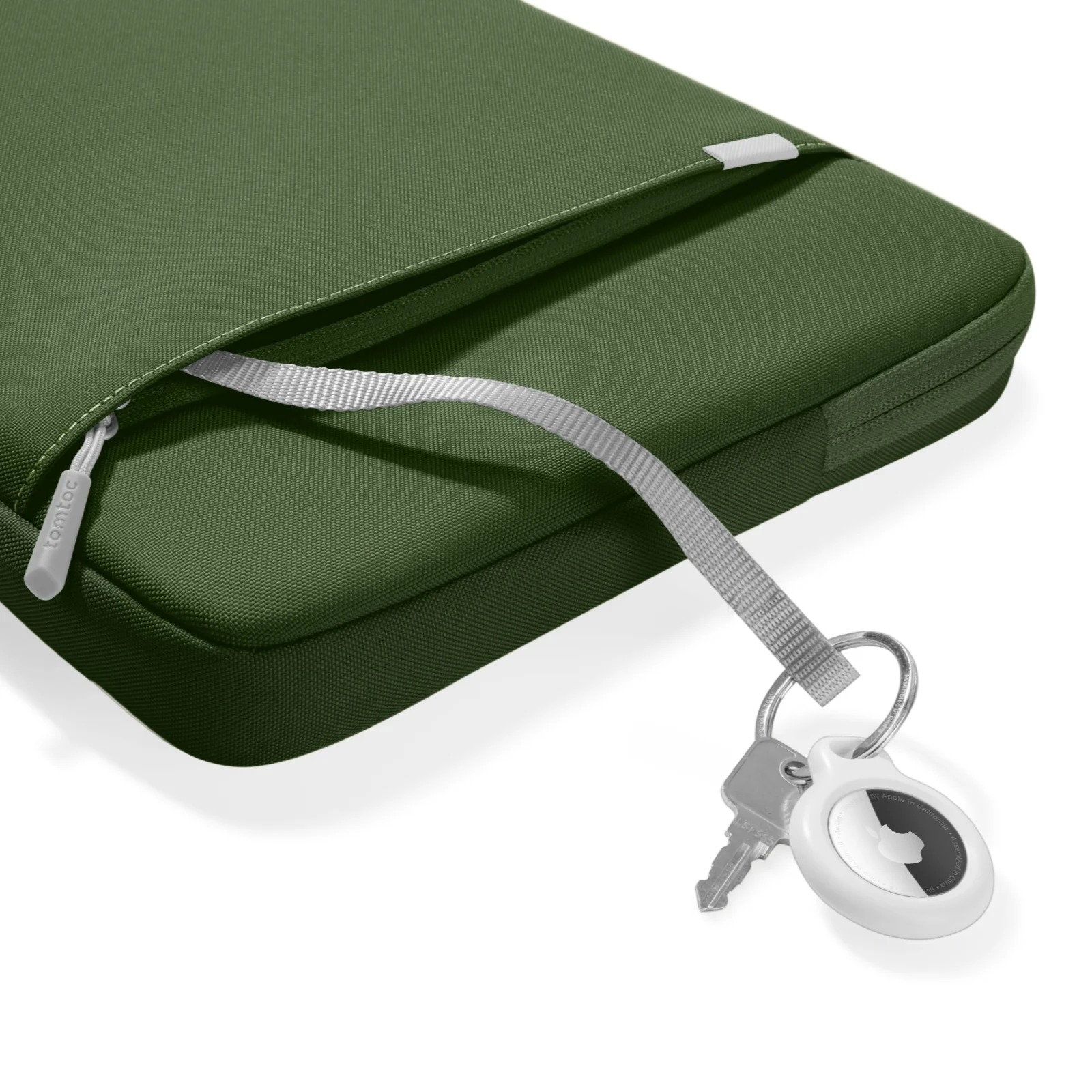 Zielona torba na laptopa z dołączonymi kluczami. Białe tło.