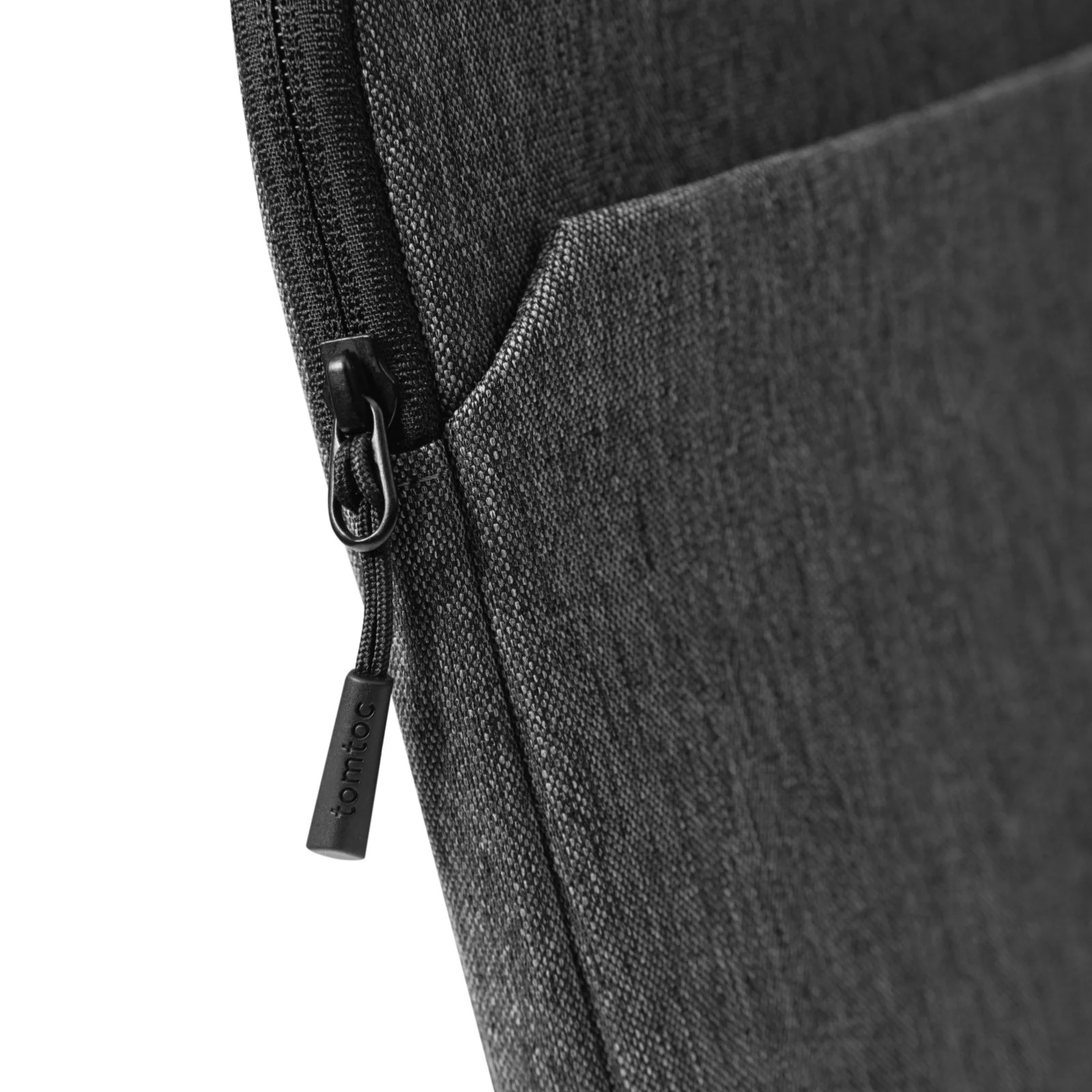 Zbliżenie czarnego zamka błyskawicznego z logo tomtoc na czarnej torbie na laptopa.