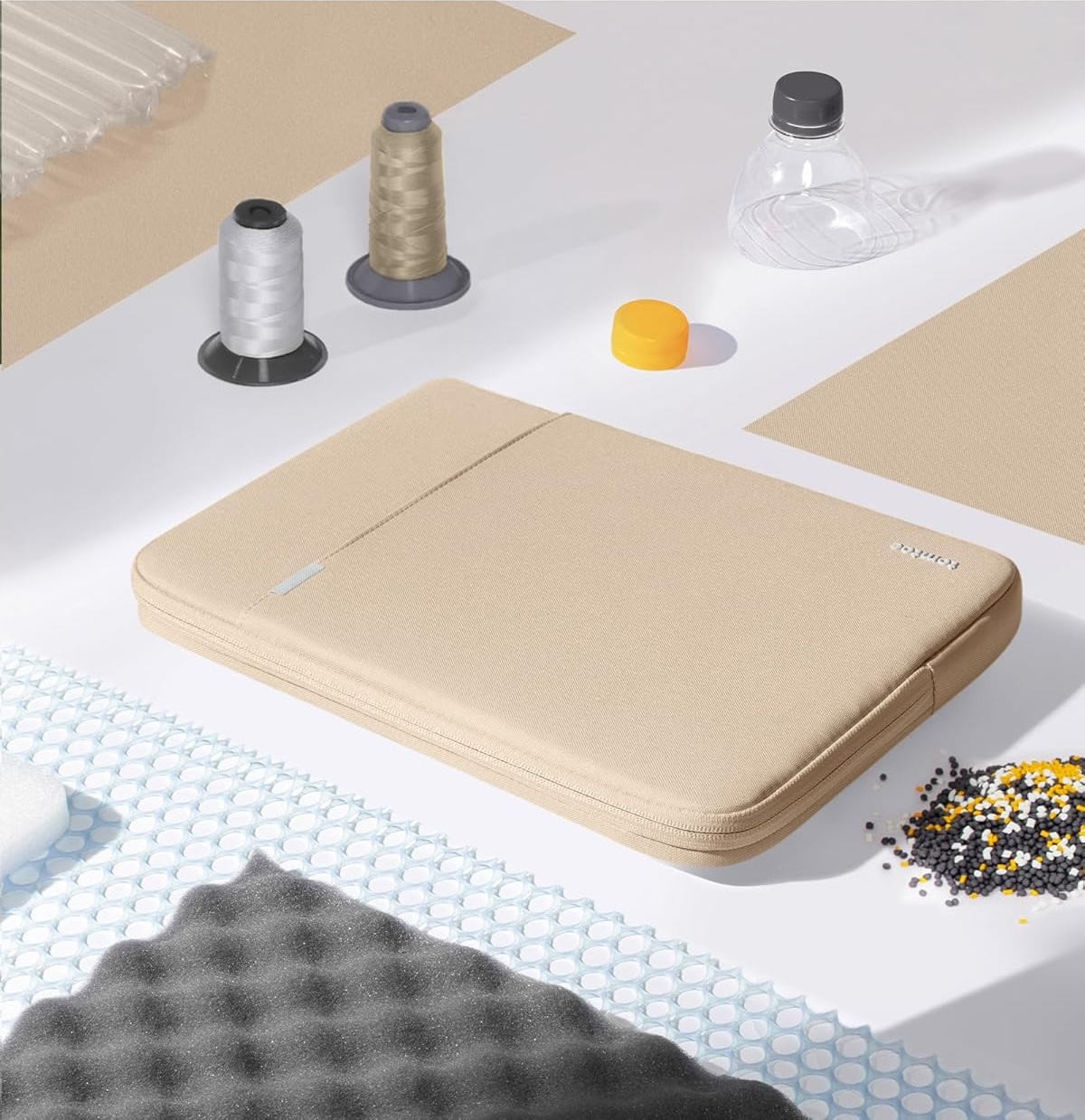 Torba na laptopa i akcesoria na białej powierzchni. Szpule, koraliki i inne przedmioty.