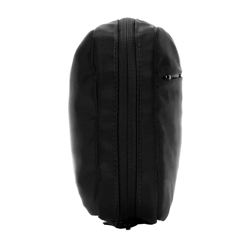 Organizzatore tecnologico nero chiuso e con cerniera, vista laterale, con una cerniera che corre lungo il lato.