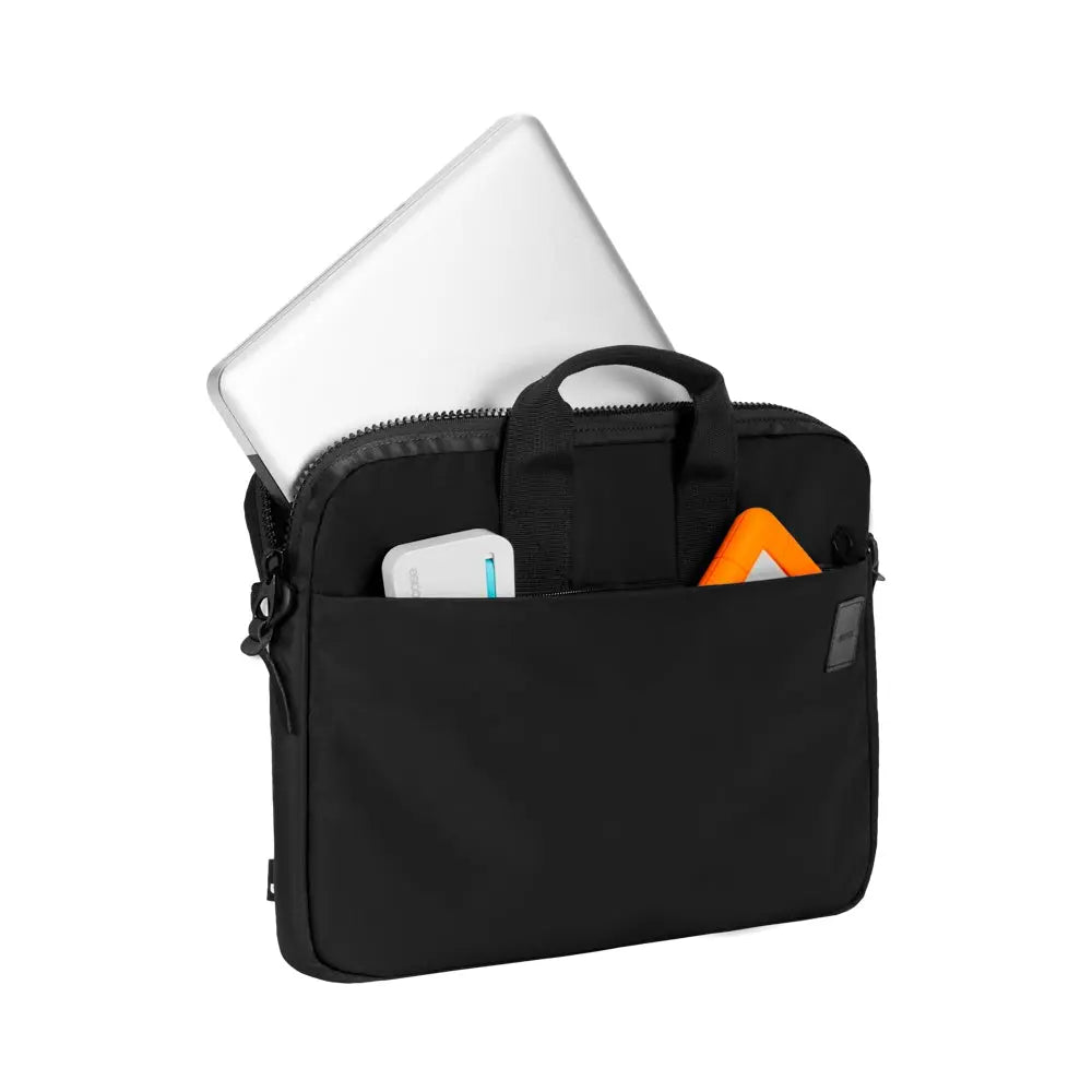 Borsa nera per laptop con laptop. Dispositivo bianco e oggetto arancione in tasca.
