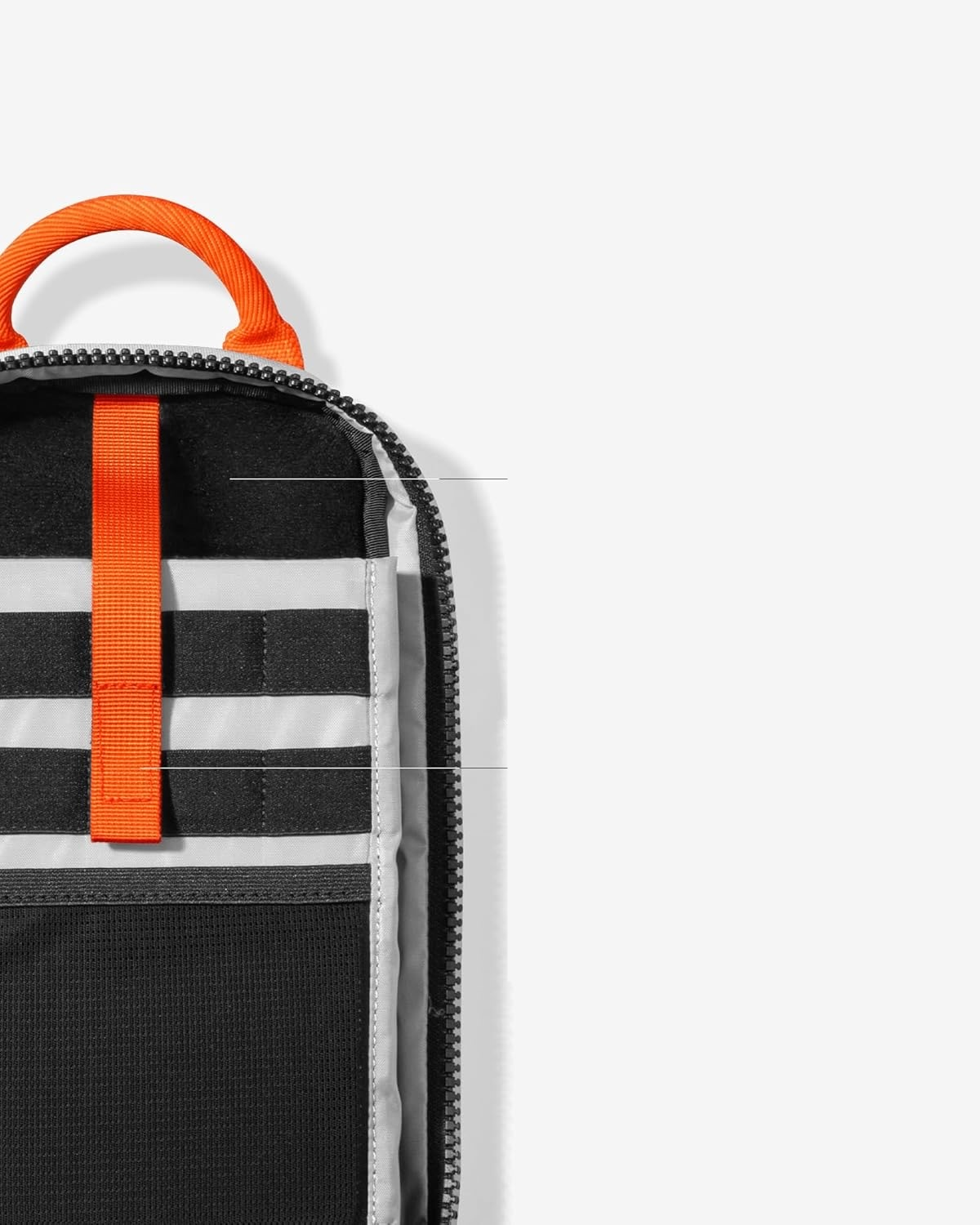 Otwarte wnętrze torby z wieloma przegródkami i pomarańczowym paskiem.