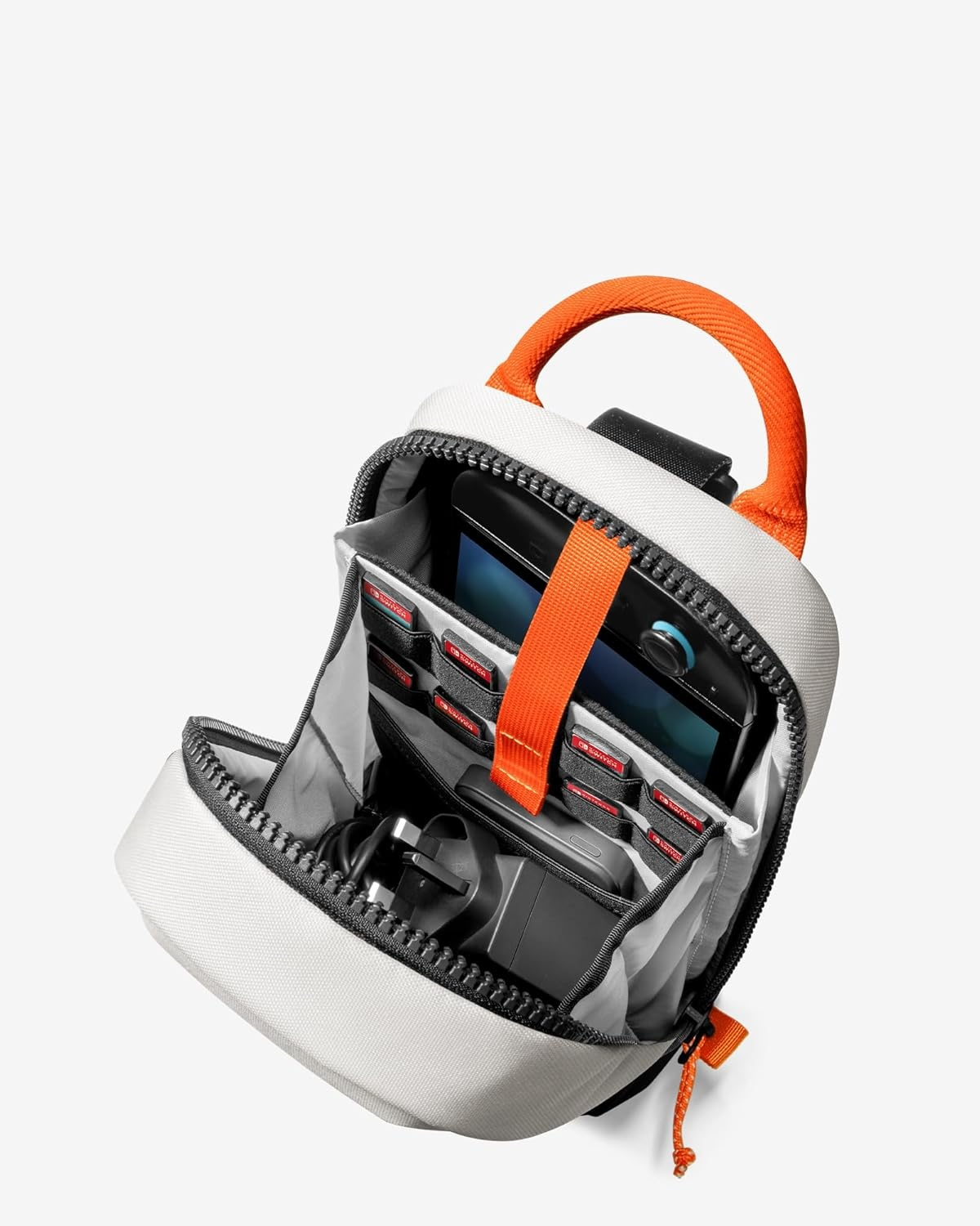 Otwarta torba na ramię z konsolą Switch i akcesoriami w środku, białe tło.