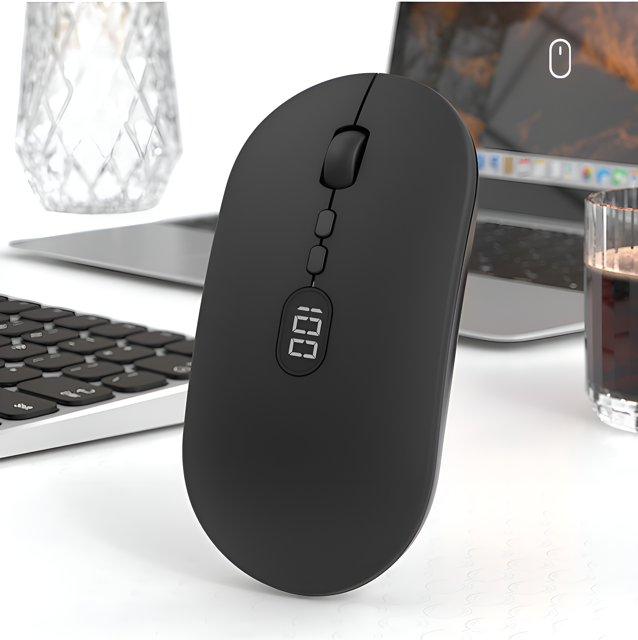 Schwarze Maus mit Digitalanzeige auf einem Schreibtisch neben Tastatur, Glas und Laptop.