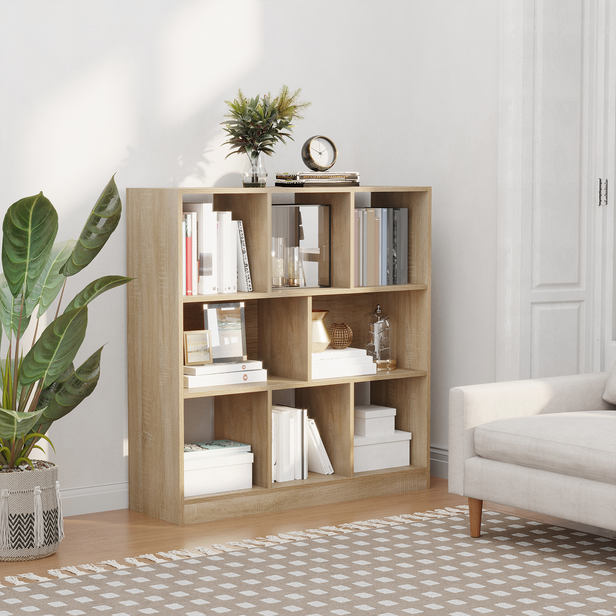 Ein helles Bücherregal aus Holz ist mit Büchern, Dekorationsartikeln und einer Pflanze gefüllt.