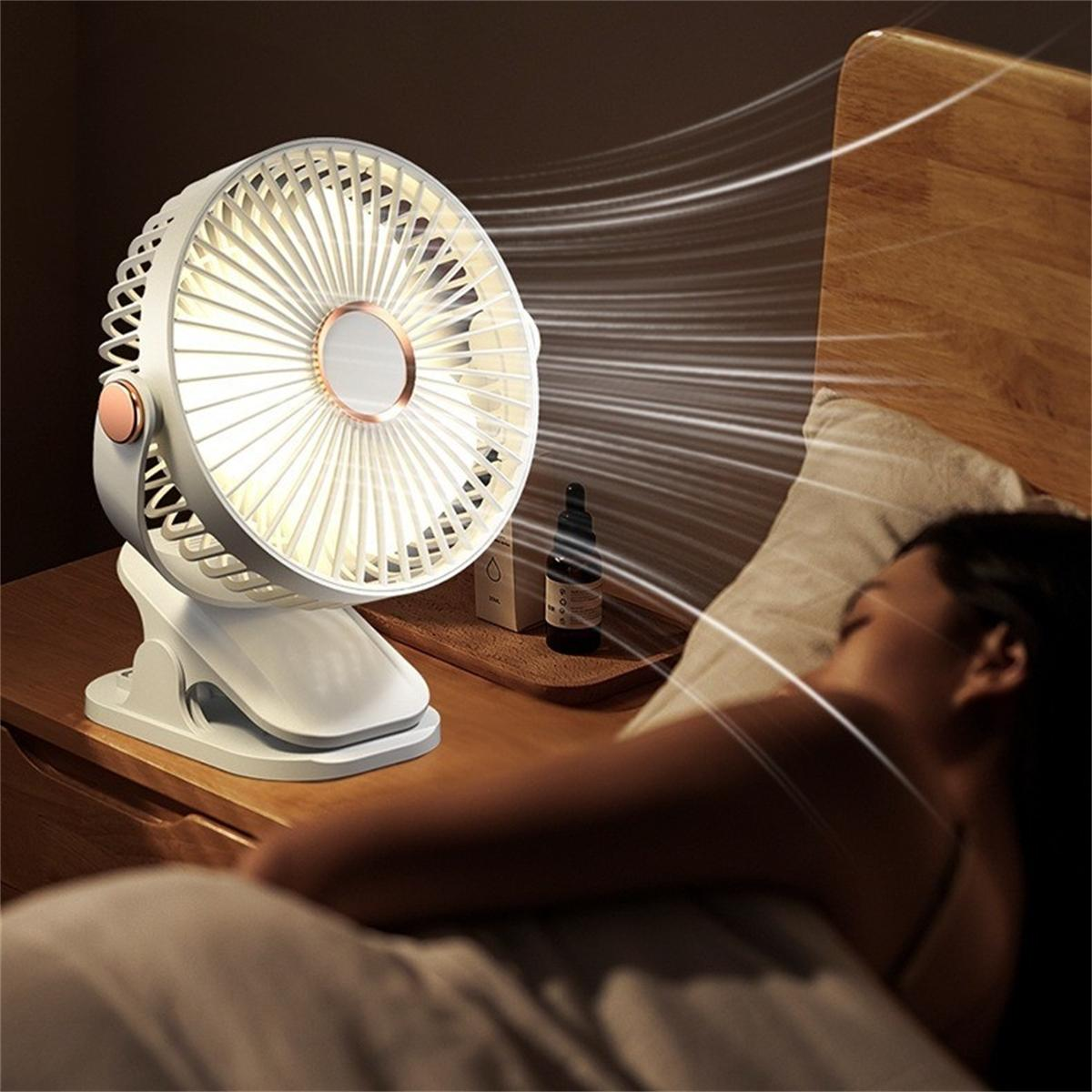 Ein weißer Ventilator, der an einem Nachttisch befestigt ist und Luft auf schlafende Person bläst.