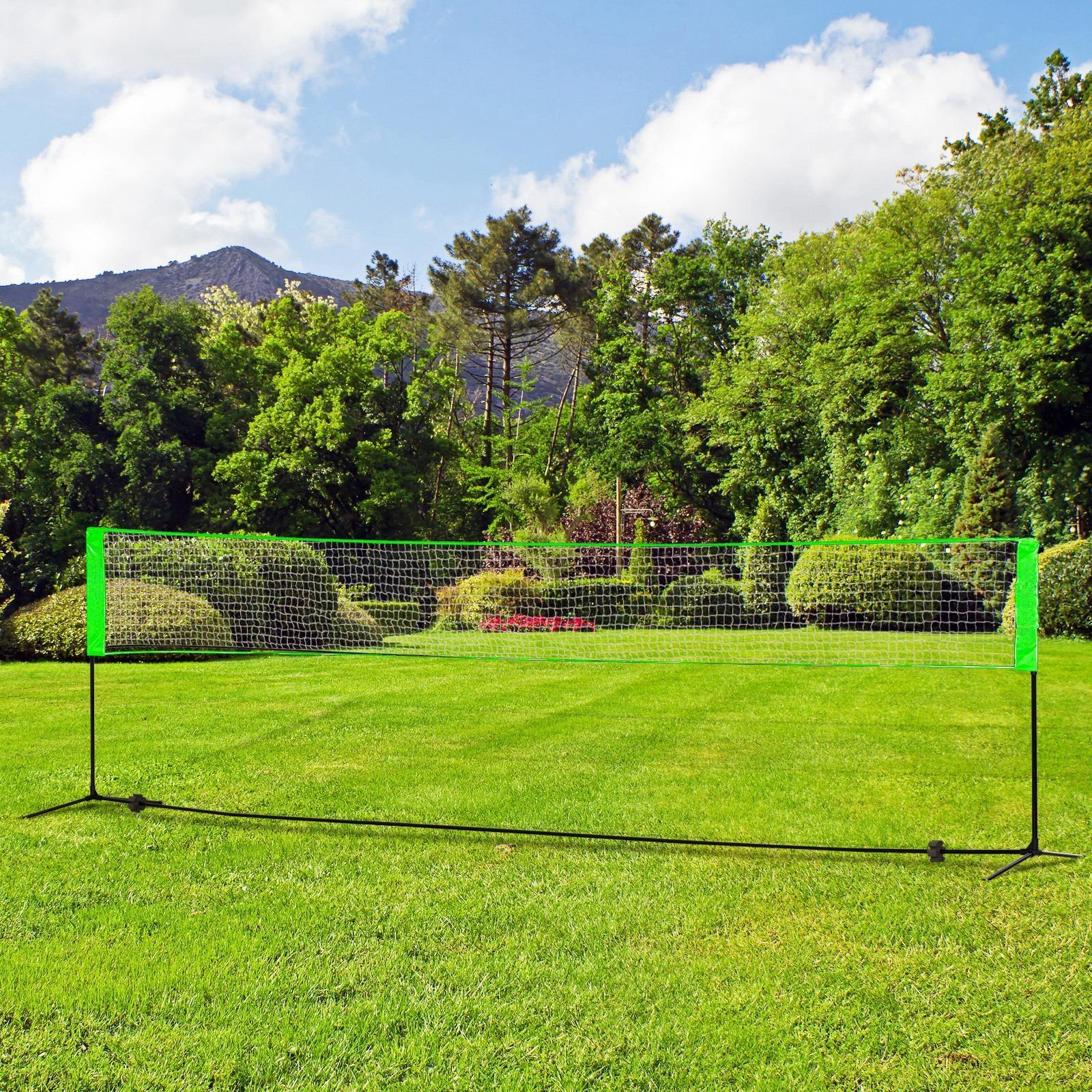 Ein Badmintonnetz, das auf grünem Gras mit Bäumen im Hintergrund aufgebaut ist. Es ist ein sonniger Tag, und die Szene ist im Freien.