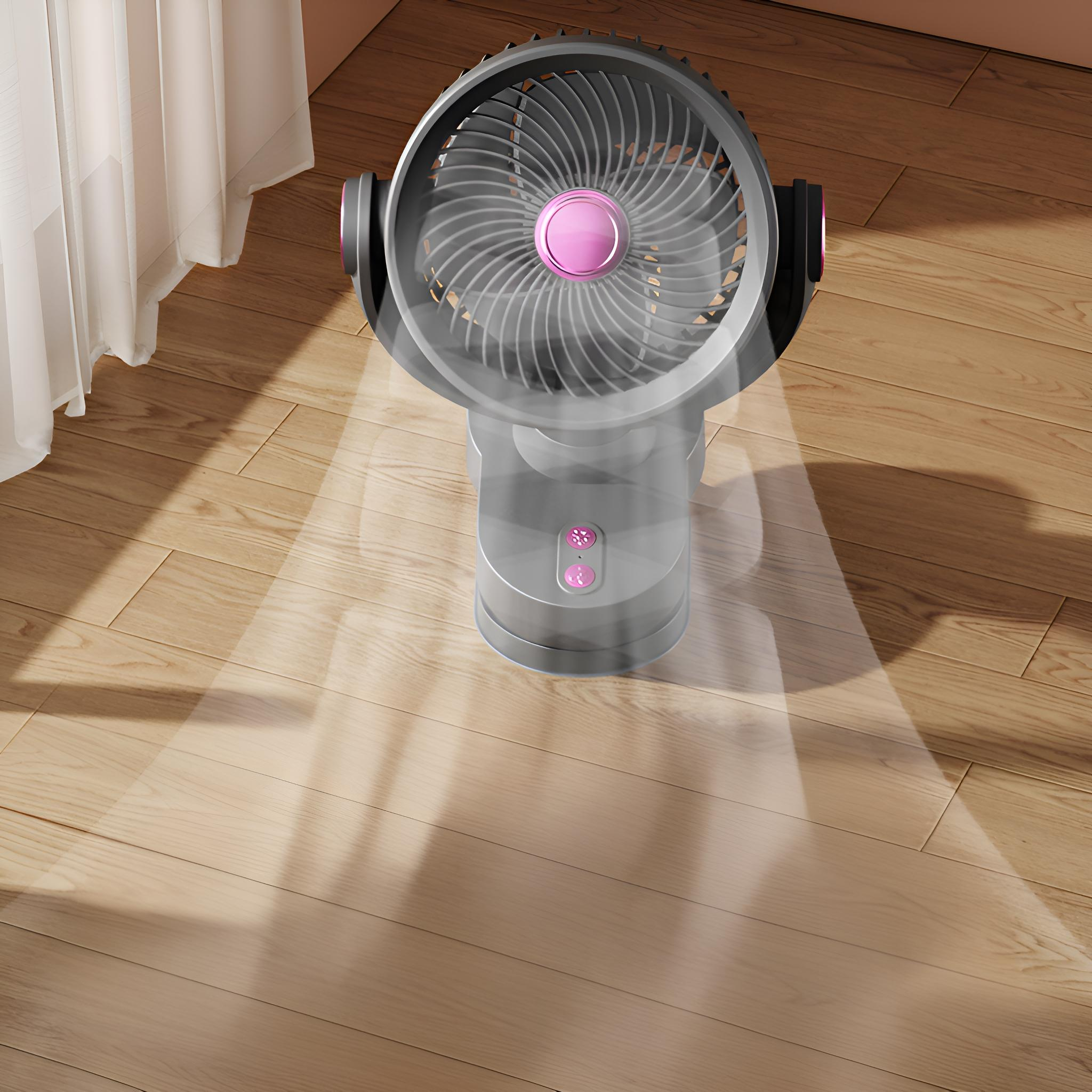Ein grauer Ventilator auf einem Holzboden, zum Betrachter geneigt. Licht scheint vom Ventilator, der Hintergrund ist unscharf.