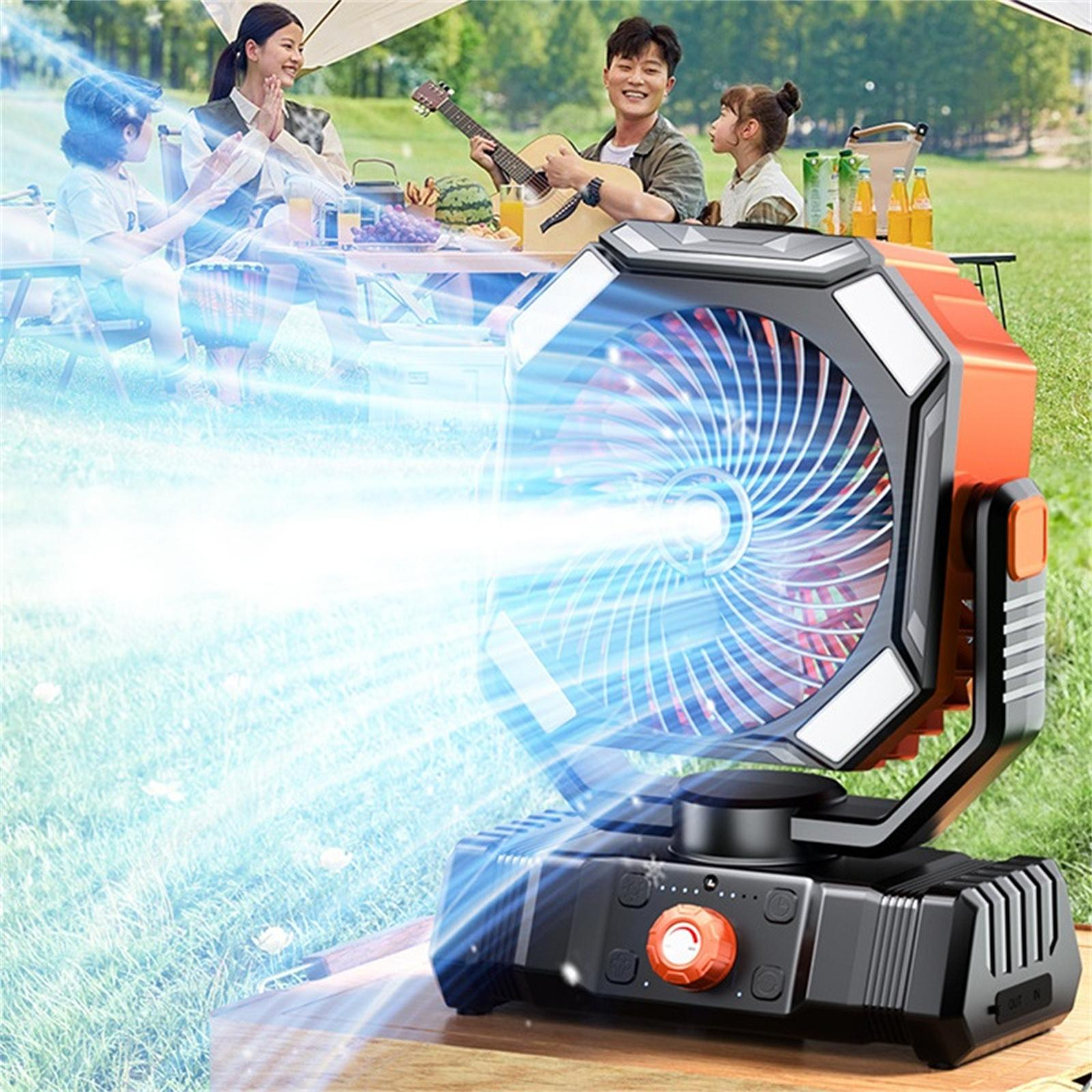Ein orangefarbener und schwarzer Ventilator, der Luft auf eine picknickende Familie bläst. Eine Person spielt Gitarre.