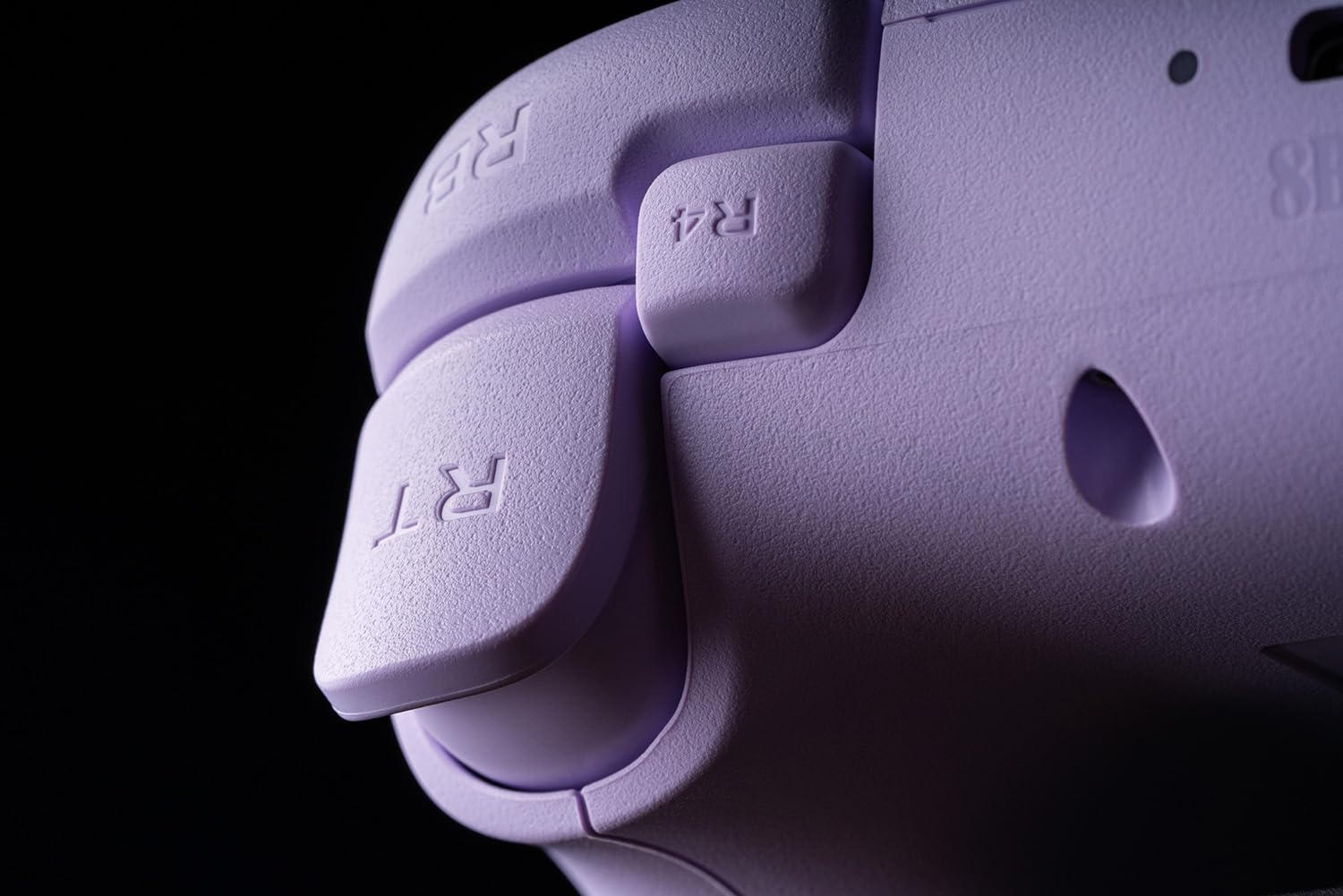 Zbliżenie przycisków fioletowego kontrolera do gier. Skupienie na przyciskach 'R4' i 'RT'.