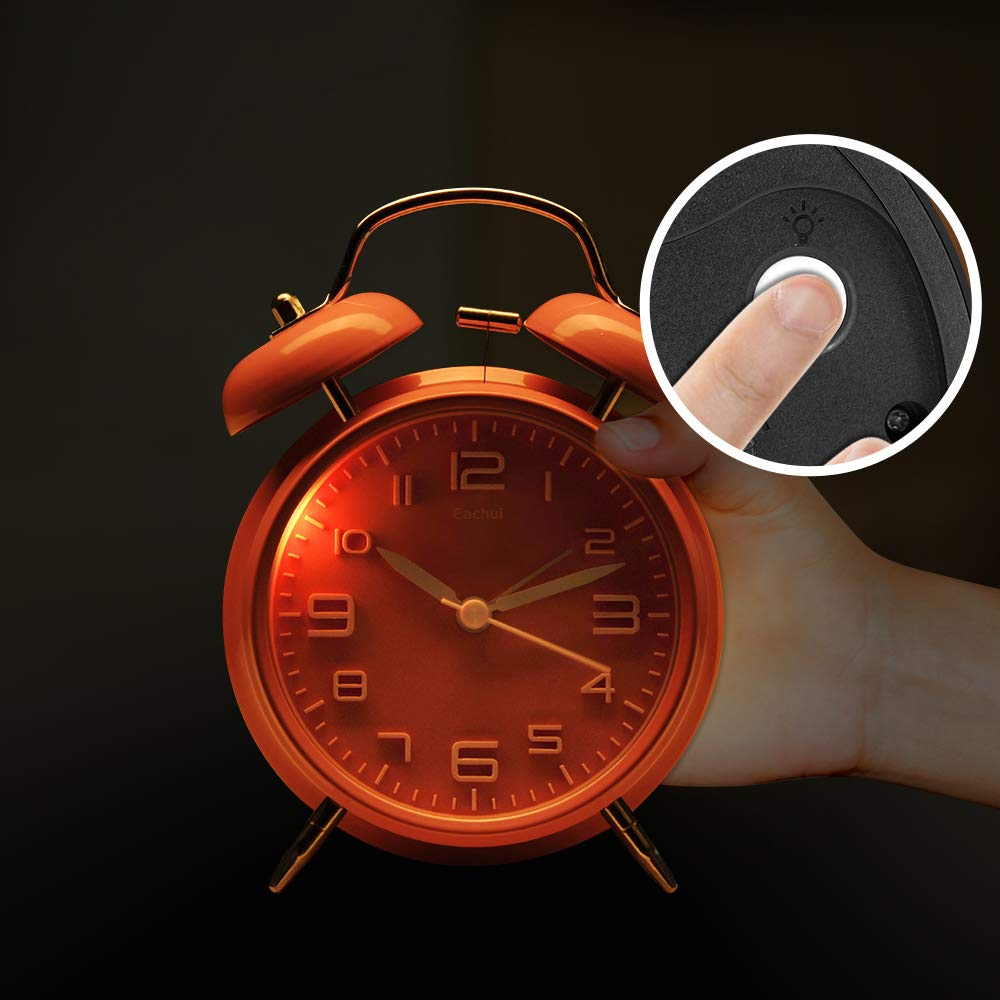 Orangener Wecker mit einer Hand, die einen Knopf auf der Rückseite drückt, runder Einsatz zeigt Lichtsymbol.