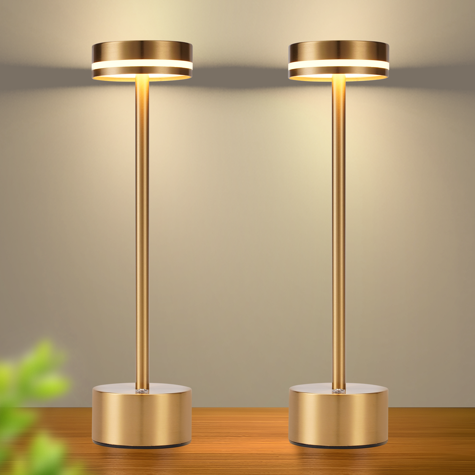 Dwie złote lampy stołowe z jasnym, białym światłem. Stoją na drewnianej powierzchni.