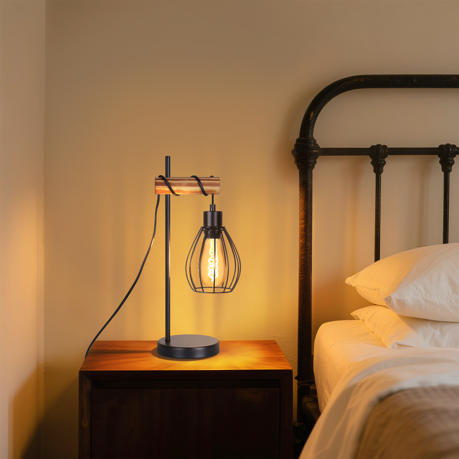 Czarna metalowa lampa stołowa w stylu klatki z drewnianym blatem na drewnianej szafce nocnej obok łóżka.