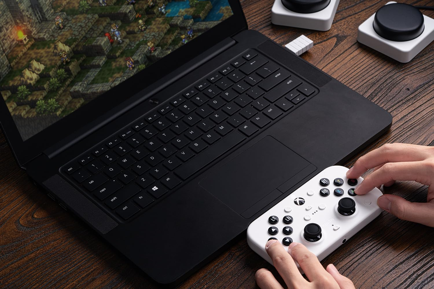 Una persona juega en un portátil con un mando blanco. El juego es visible.