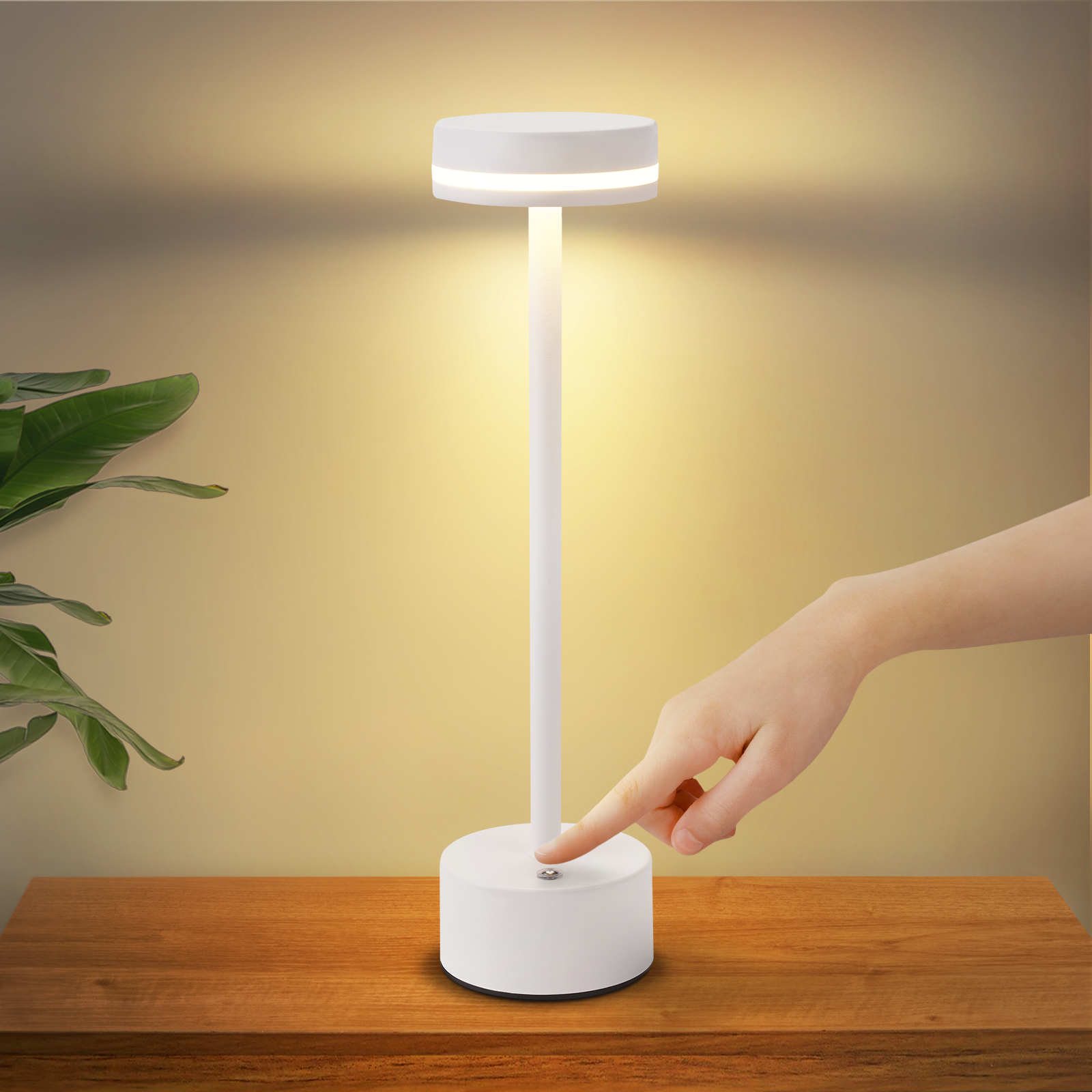 Biała lampka nocna, ręka naciska przycisk na podstawie, na drewnianym stole.