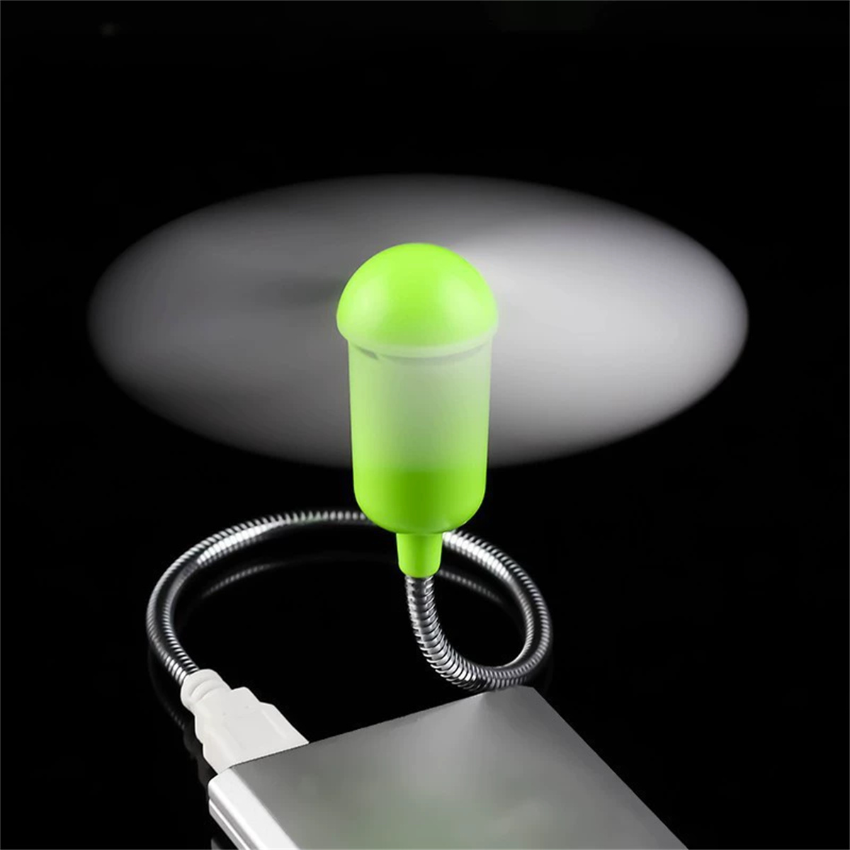 Ein USB-Ventilator mit grünem Kopf und silbernem, flexiblem Hals auf schwarzem Hintergrund.