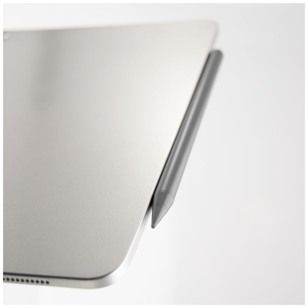 Ein grauer Stylus-Stift liegt auf einem silbernen Tablet. Der Stift ist diagonal positioniert.