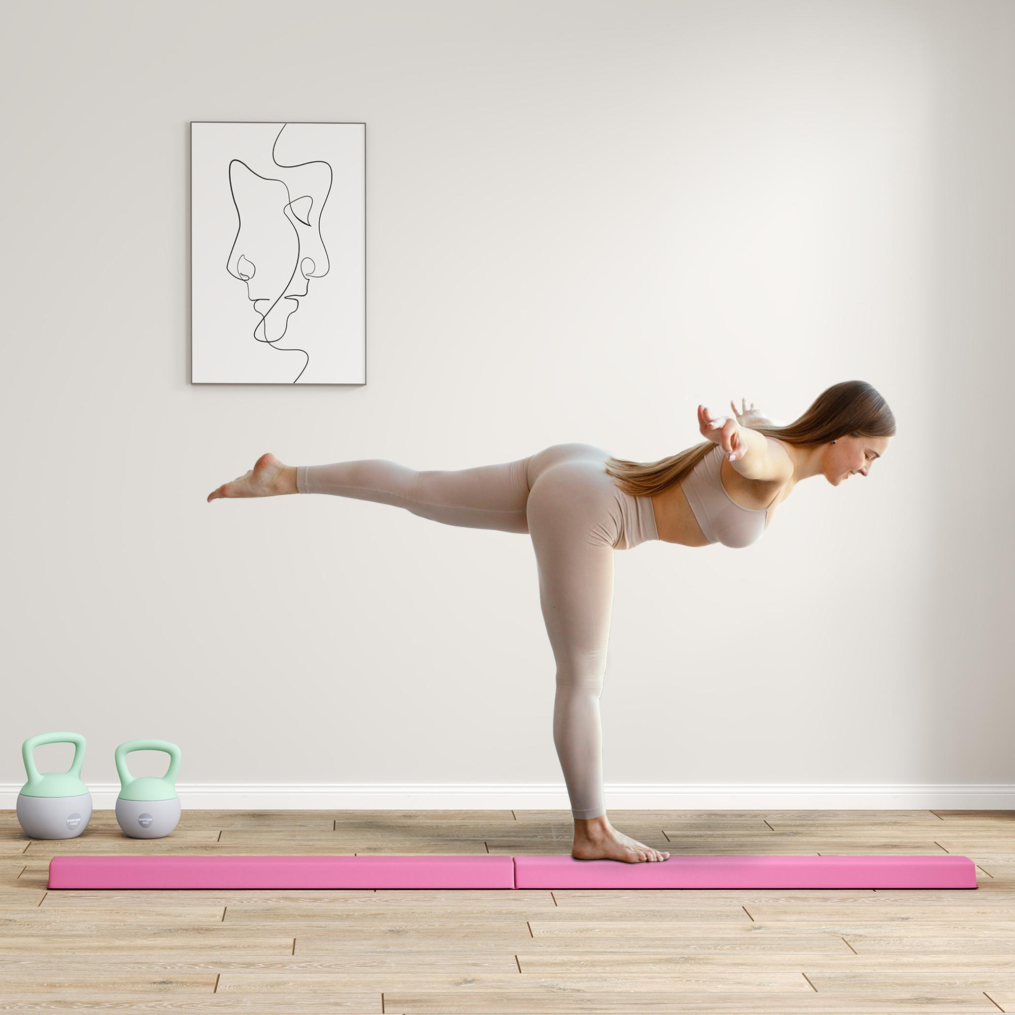 Eine Frau in Sportkleidung balanciert auf einem Bein mit ausgestreckten Armen in einer Yoga-Pose.