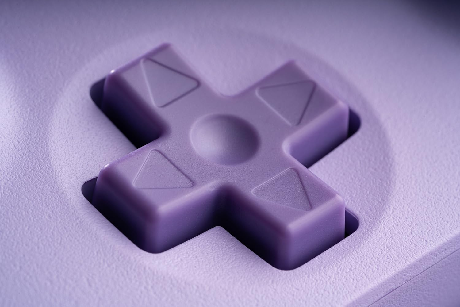 Zbliżenie krzyżakowego pada kierunkowego na fioletowym kontrolerze do gier.