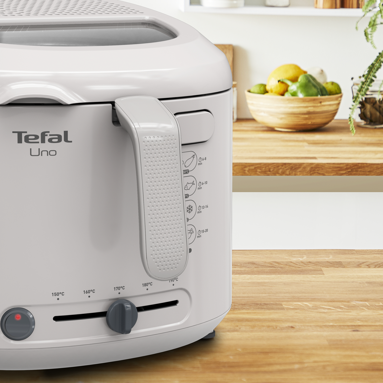 Un primo piano di una friggitrice Tefal Uno bianca con manico e quadranti di controllo su una superficie in legno.