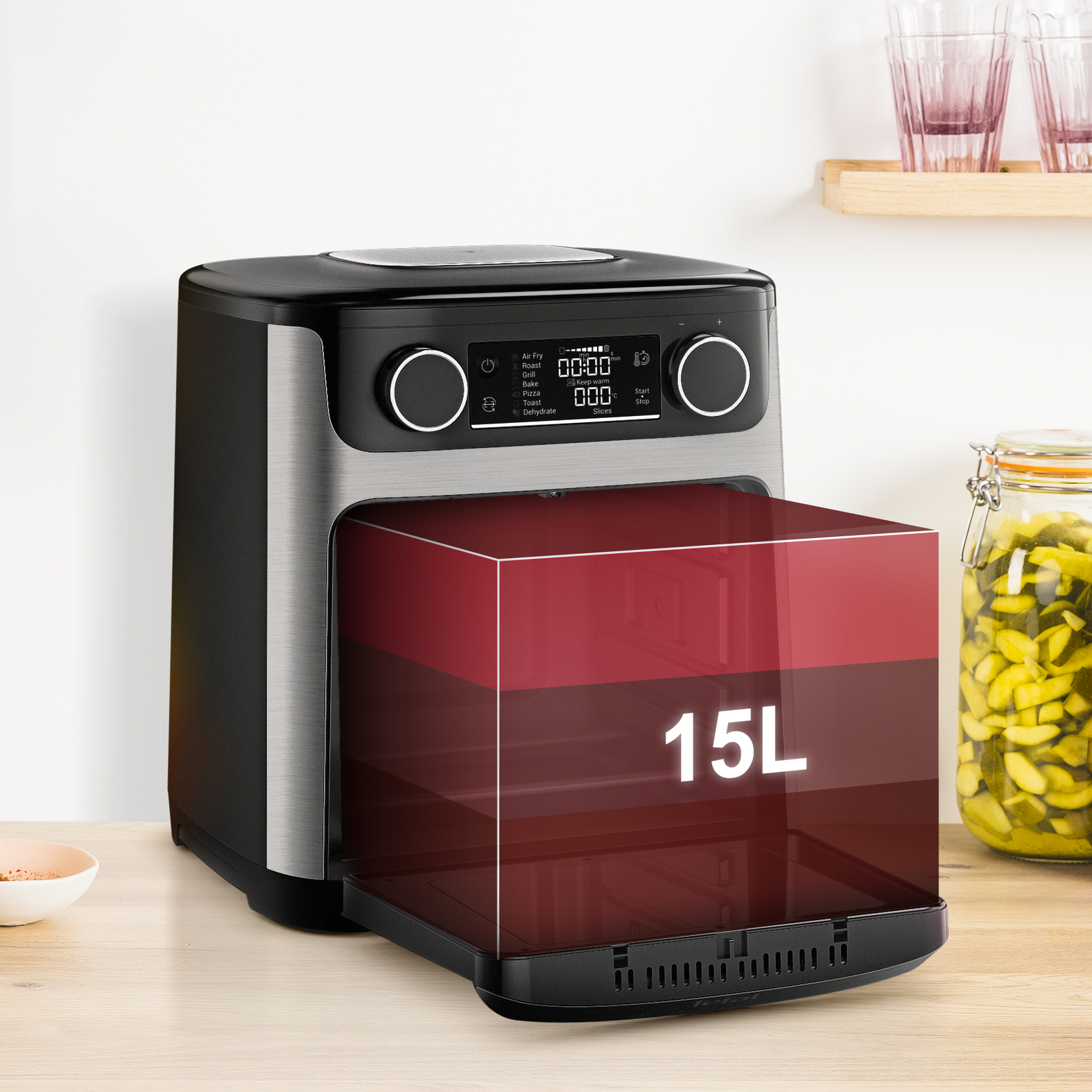 Frytkownica powietrzna z przezroczystym czerwonym pudełkiem pokazującym pojemność 15L. Frytkownica stoi na drewnianej powierzchni.