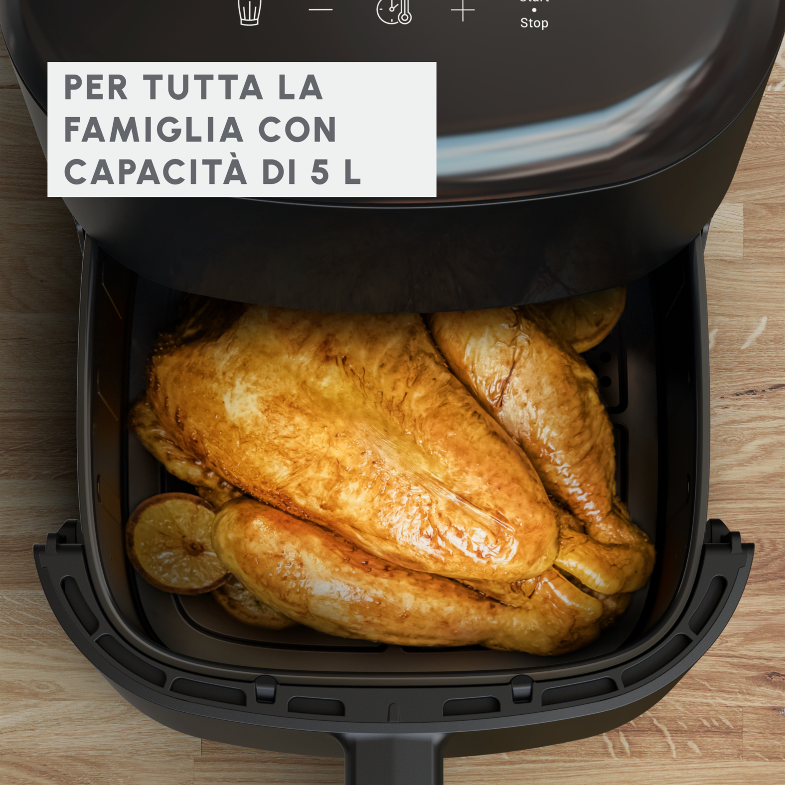 Czarna frytkownica powietrzna z całym upieczonym kurczakiem w środku.