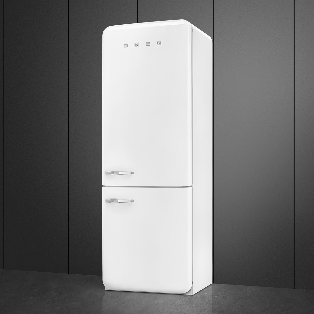 Un refrigerador SMEG blanco alto con dos puertas y manijas plateadas contra una pared y un piso grises.