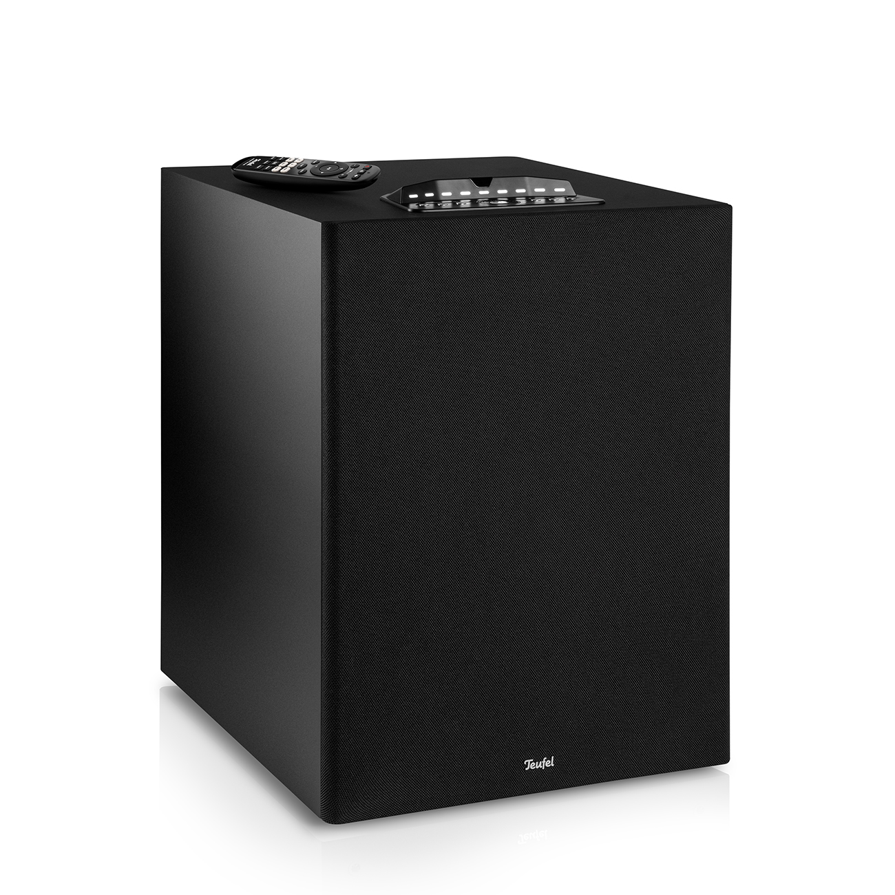 Schwarzer Subwoofer mit Fernbedienung oben. Teufel-Logo unten und Bedienfeld. Weißer Hintergrund.