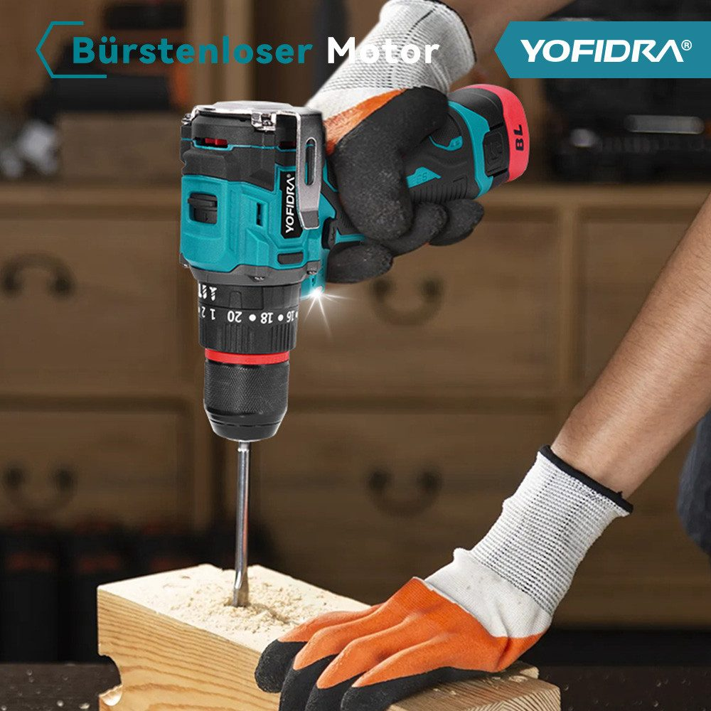 Eine Person bohrt mit einem teal-schwarzen Akku-Bohrer in Holz. Sie tragen Handschuhe. Der Hintergrund ist ein Holzschrank.