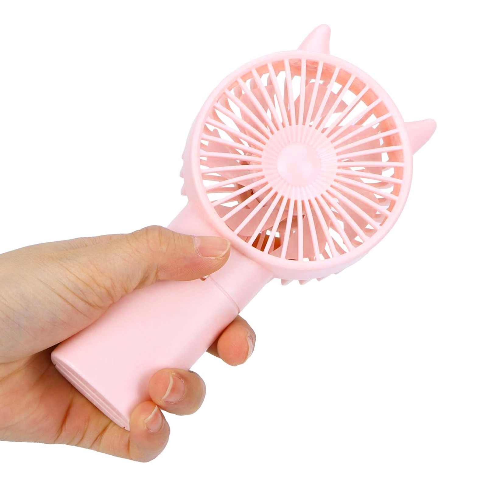 Eine Hand hält einen rosa tragbaren Ventilator. Der Ventilator hat einen kreisförmigen Kopf mit Flügeln und katzenohrartigen Vorsprüngen.