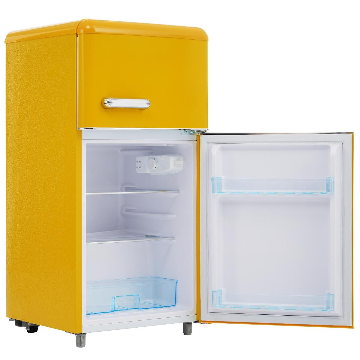 Ein gelber Retro-Kühlschrank mit offener Tür. Der Innenraum ist weiß mit Regalen und einer blauen Schublade.