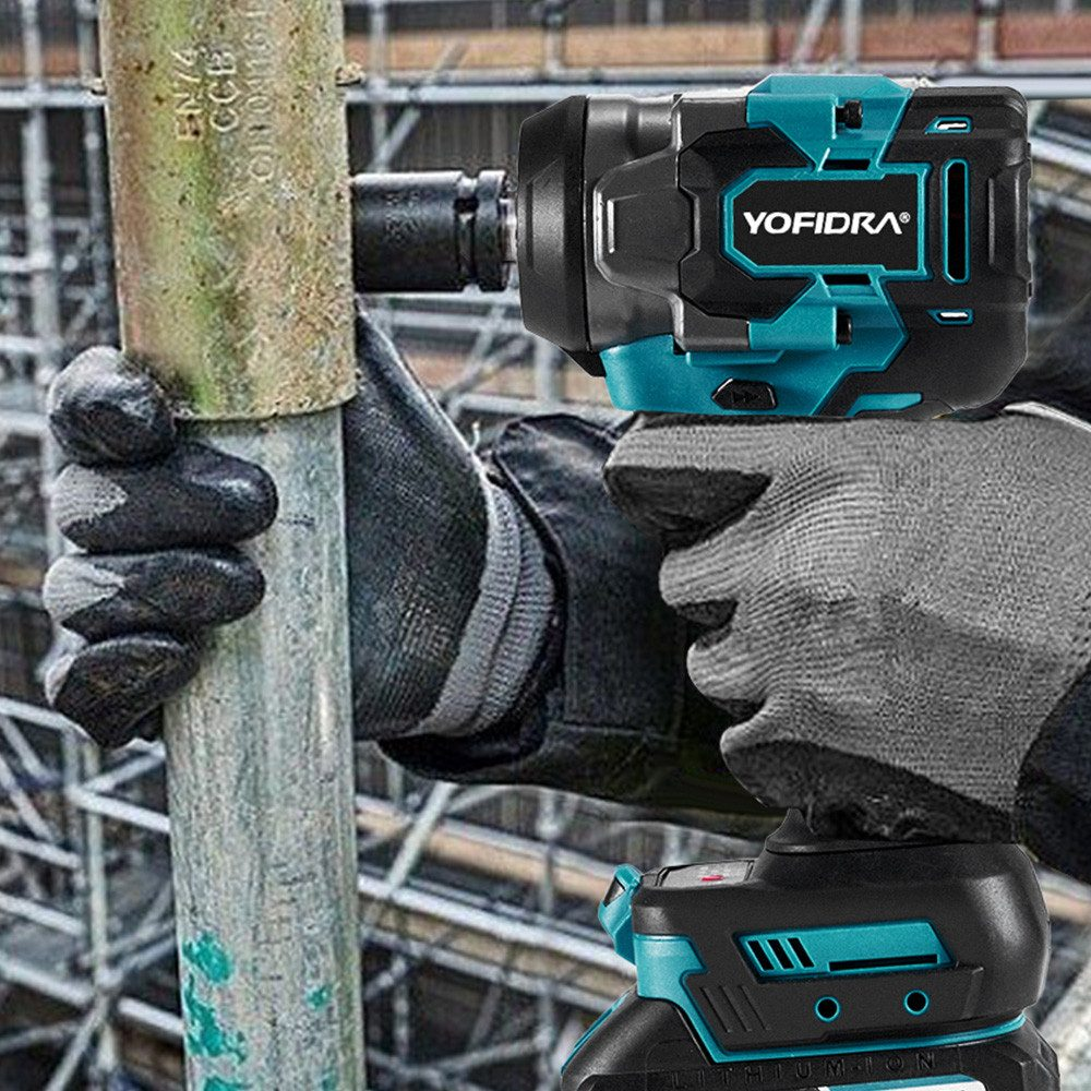 Eine Person benutzt einen schwarzen und türkisfarbenen YOFIDRA-Schlagschrauber an einer Metallstange. Sie trägt graue Handschuhe. Im Hintergrund befindet sich eine Baustelle.