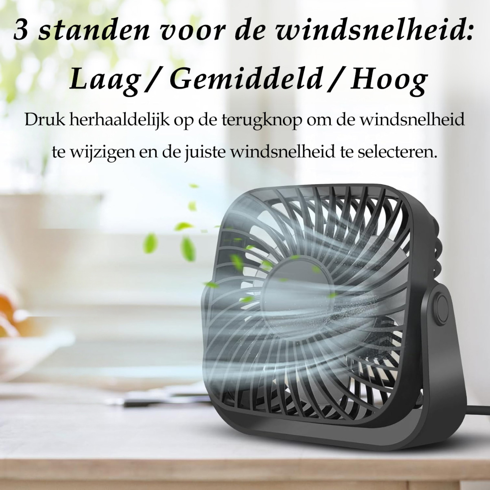 Ein schwarzer quadratischer Ventilator steht auf einem Tisch. Text: '3 Windgeschwindigkeiten: Niedrig, Mittel, Hoch'. Grüne Blätter schweben in der Luft.