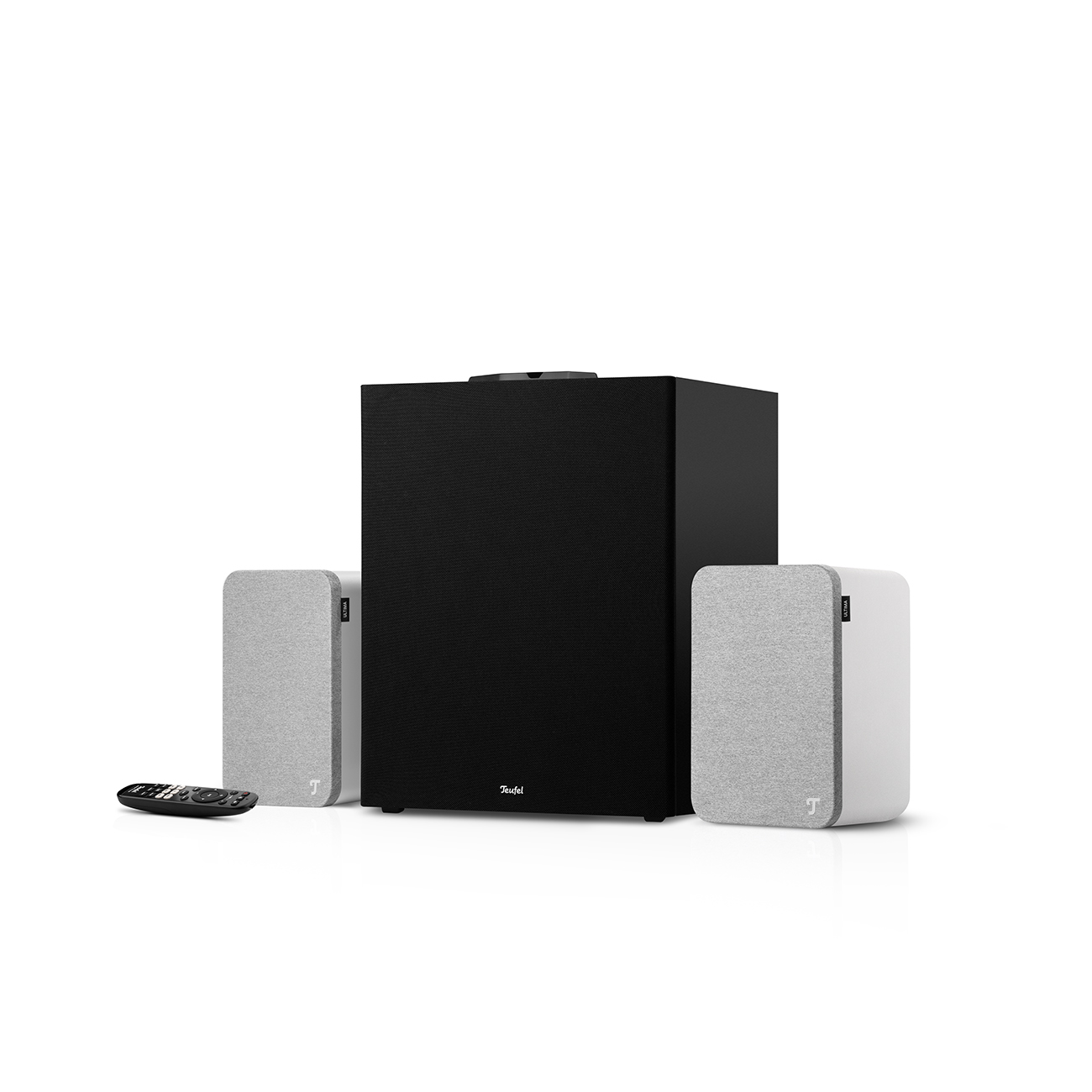 Ein schwarzer Subwoofer steht zwischen zwei hellgrauen Lautsprechern. Vorne liegt eine Fernbedienung. Der Hintergrund ist weiß.